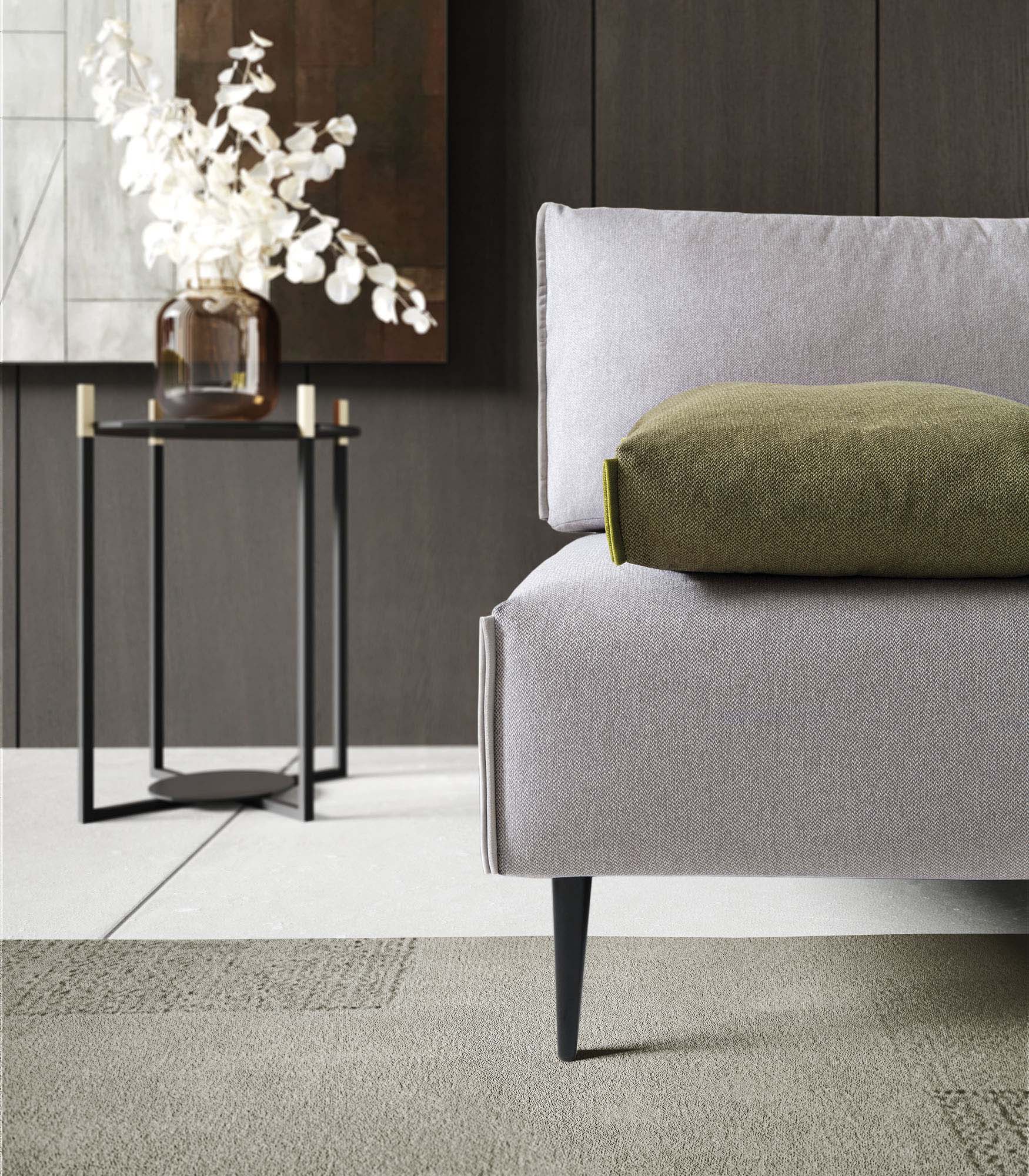 Detail of the seat of a designer sofa with high and thin legs.