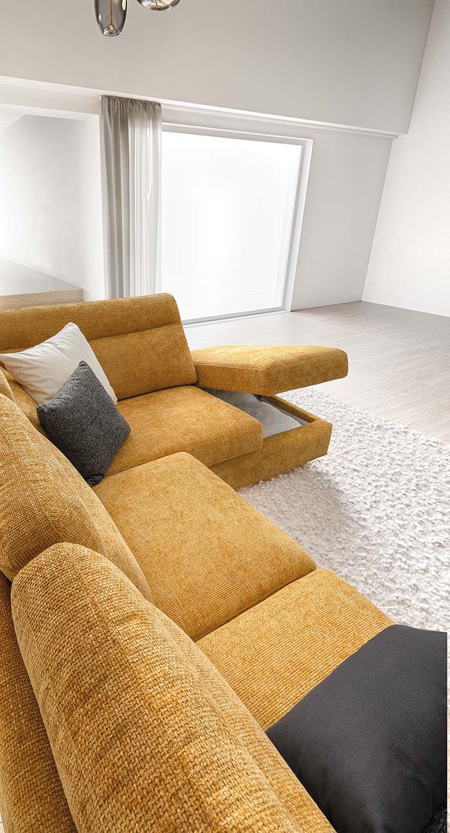 Detail of the seat of a yellow corner sofa with open storage