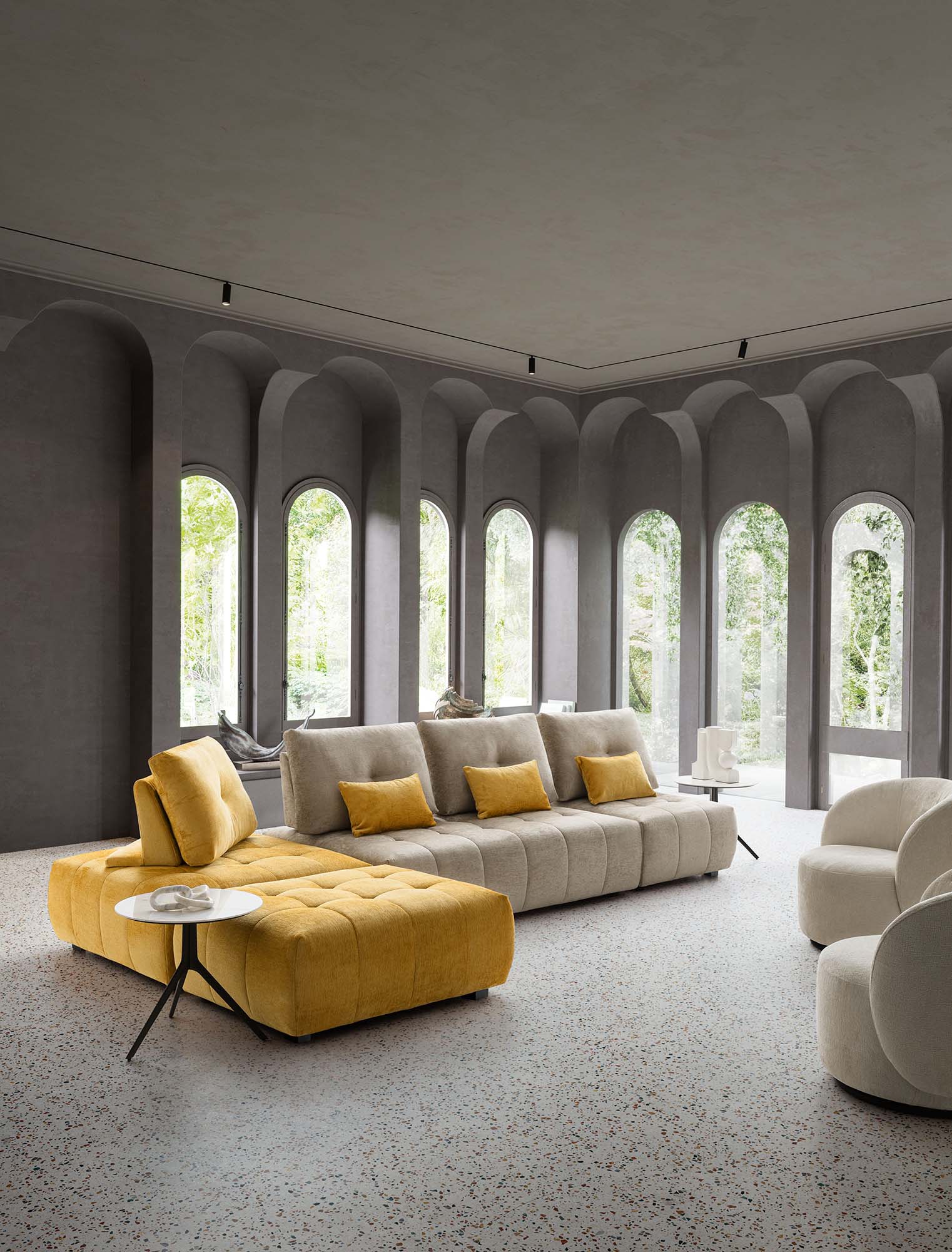 Modular sofa arranged at an angle with high sliding backrests and low legs. Quilted and design seat