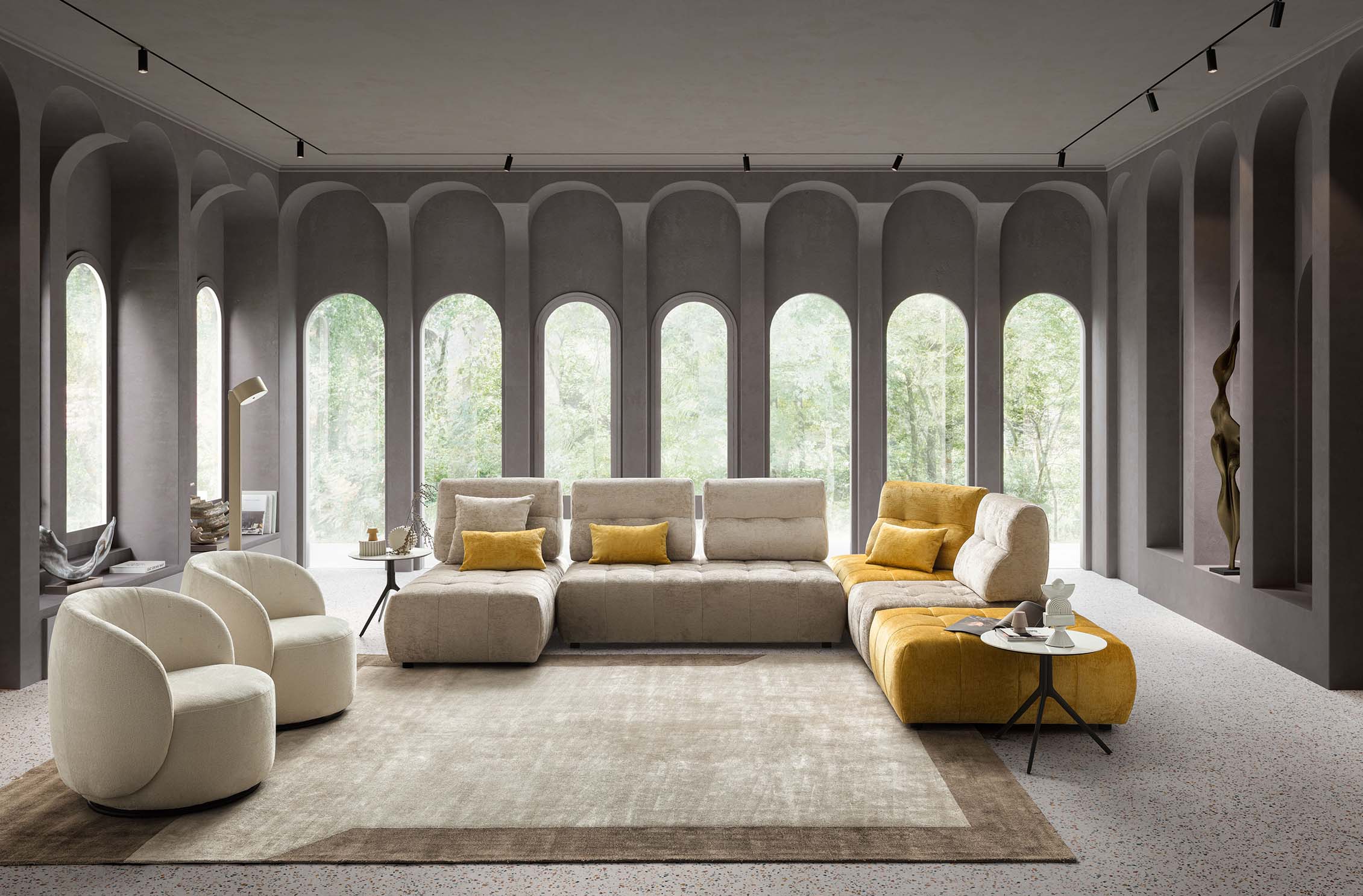 Living room composed of the Byron quilted modular sofa arranged in an L-shape with a chaise longue and two modern armchairs. Cream and yellow colors