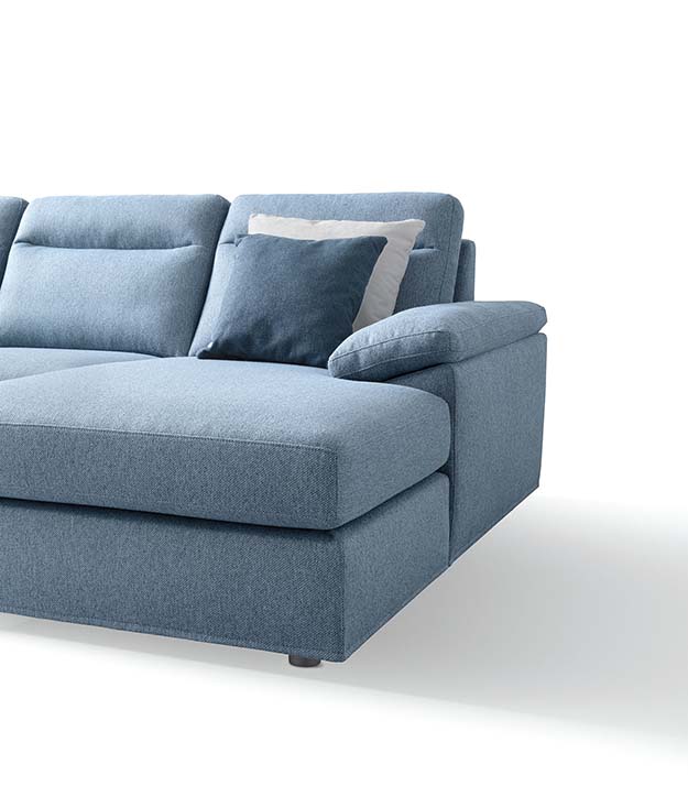 Detail of the chaise longue and simple and minimal armrest of a light blue sofa