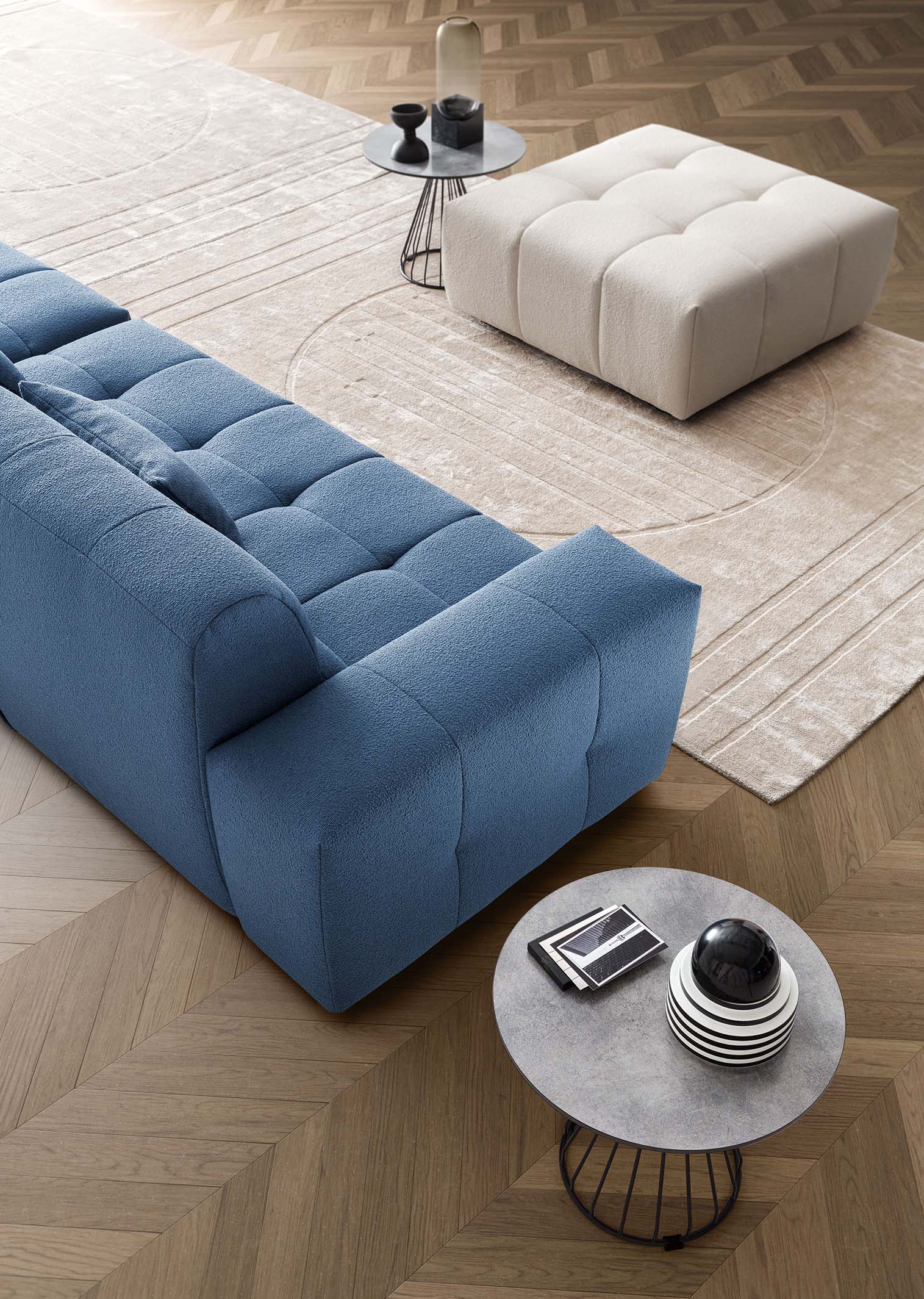 Composition of a modular sofa with linear module and separate island that can act as a pouf