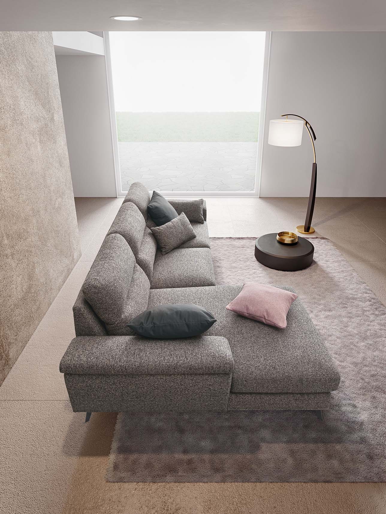 Top view of a modern sectional corner sofa in a modern living room. Contrasting gray and pink cushions