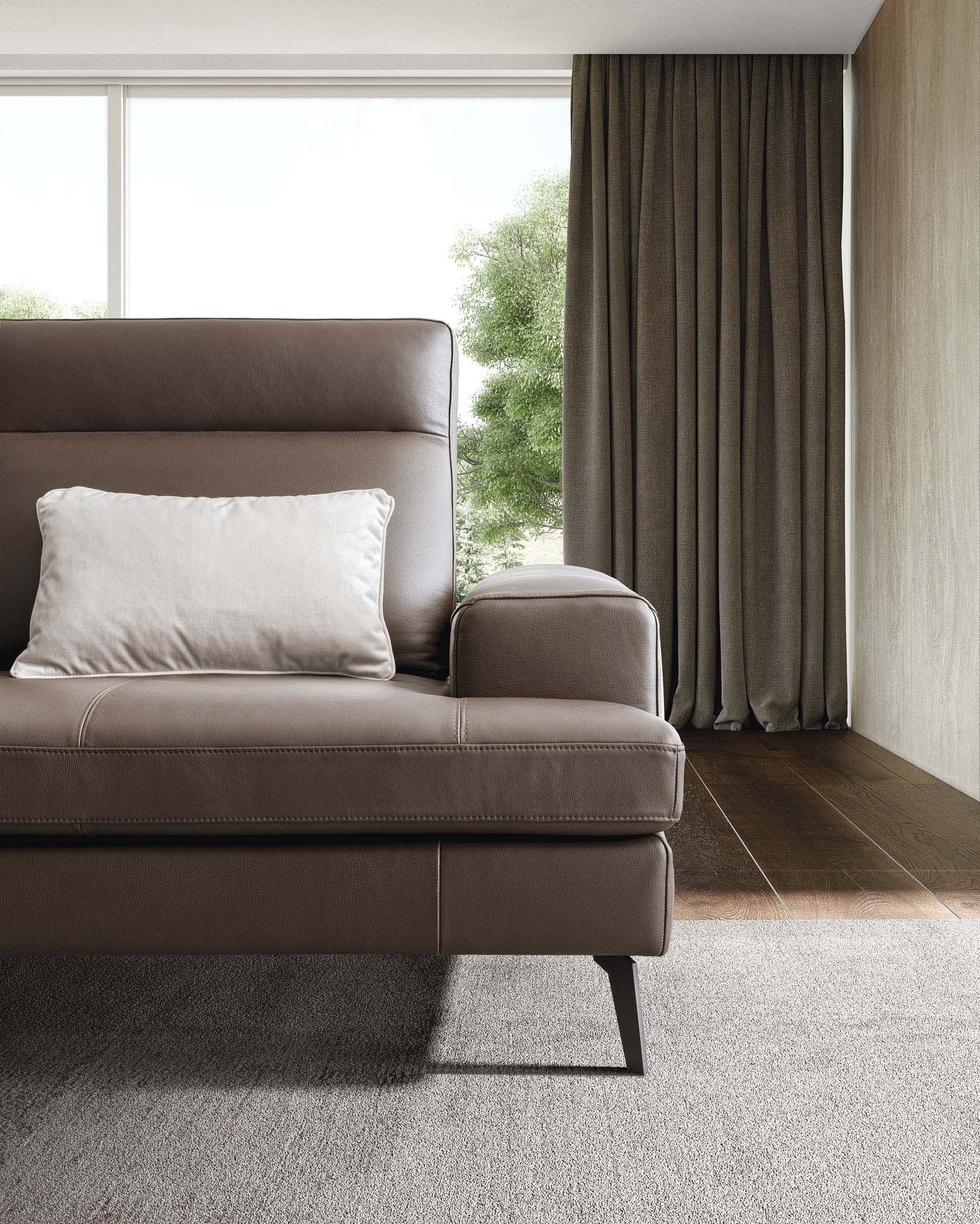 Detail of the brown leather armrest of the Emmet sofa.