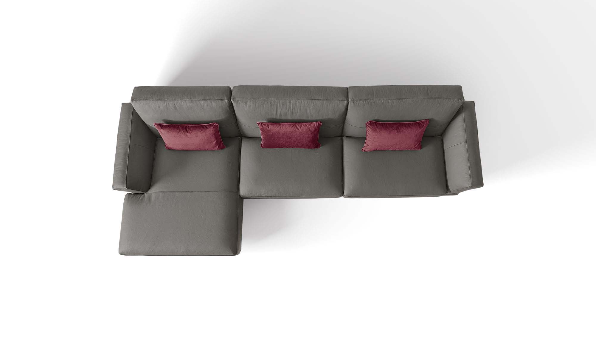 Grey three-seater chaise longue sofa with red cushions.