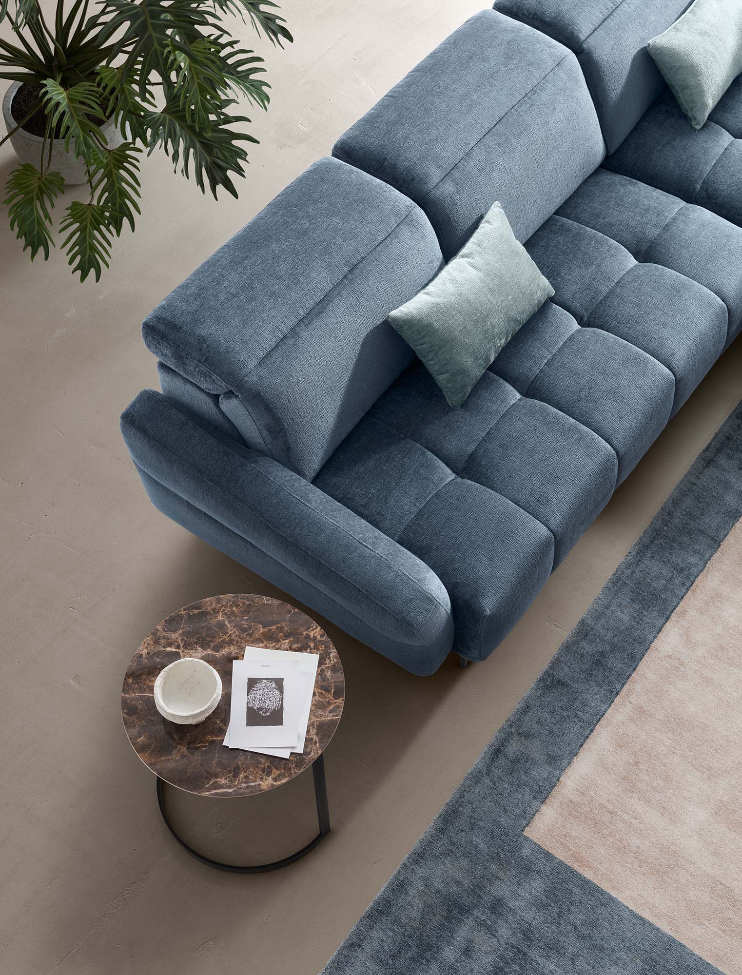 Top View of the Gillan Sofa with Light Blue Cushions Resting on the Quilted Seat. Rounded Design