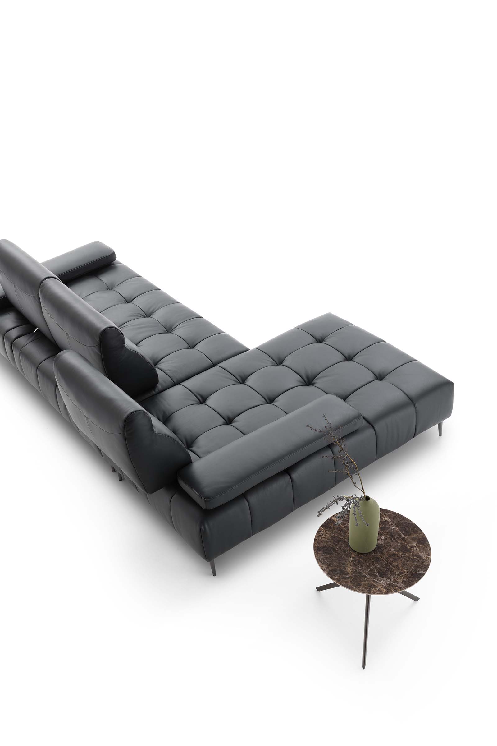 Modular quilted leather sofa configured as a chaise longue. Sliding backrest to modify the seat width