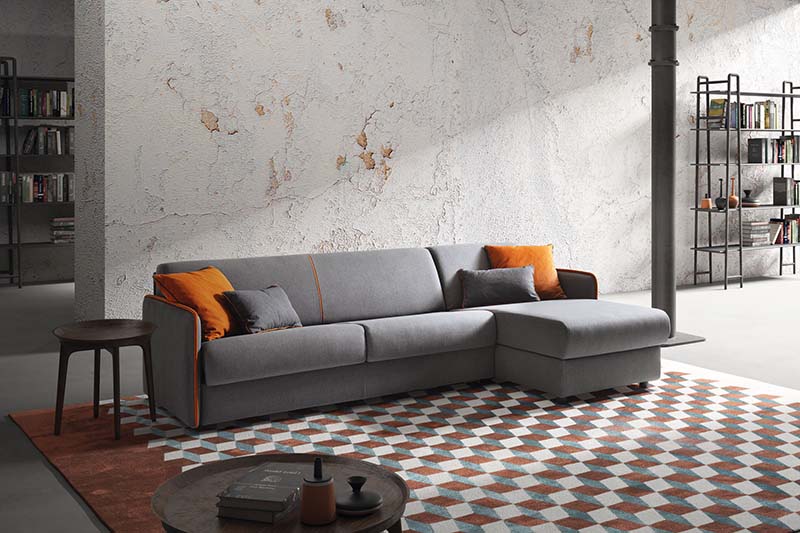 Sofa bed with lateral chaise longue. Gray color with contrasting orange cushions