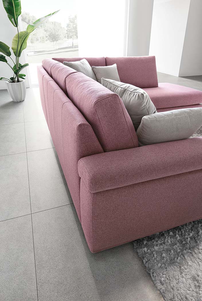 Detail of the back of the Papilio sofa with pink fabric upholstery and gray cushions