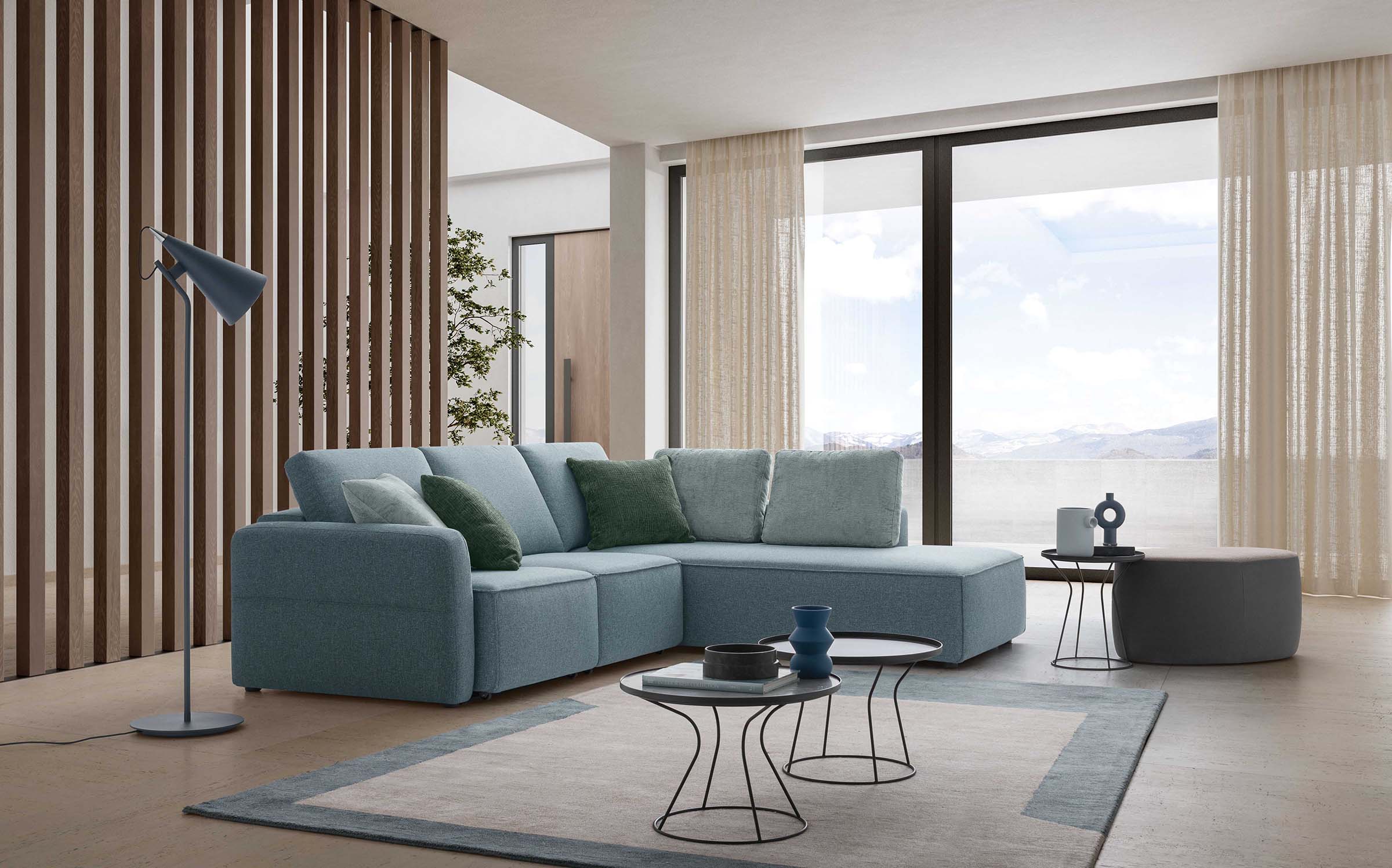 Light blue three-seater sofa with a maxi chaise longue in a mountain setting