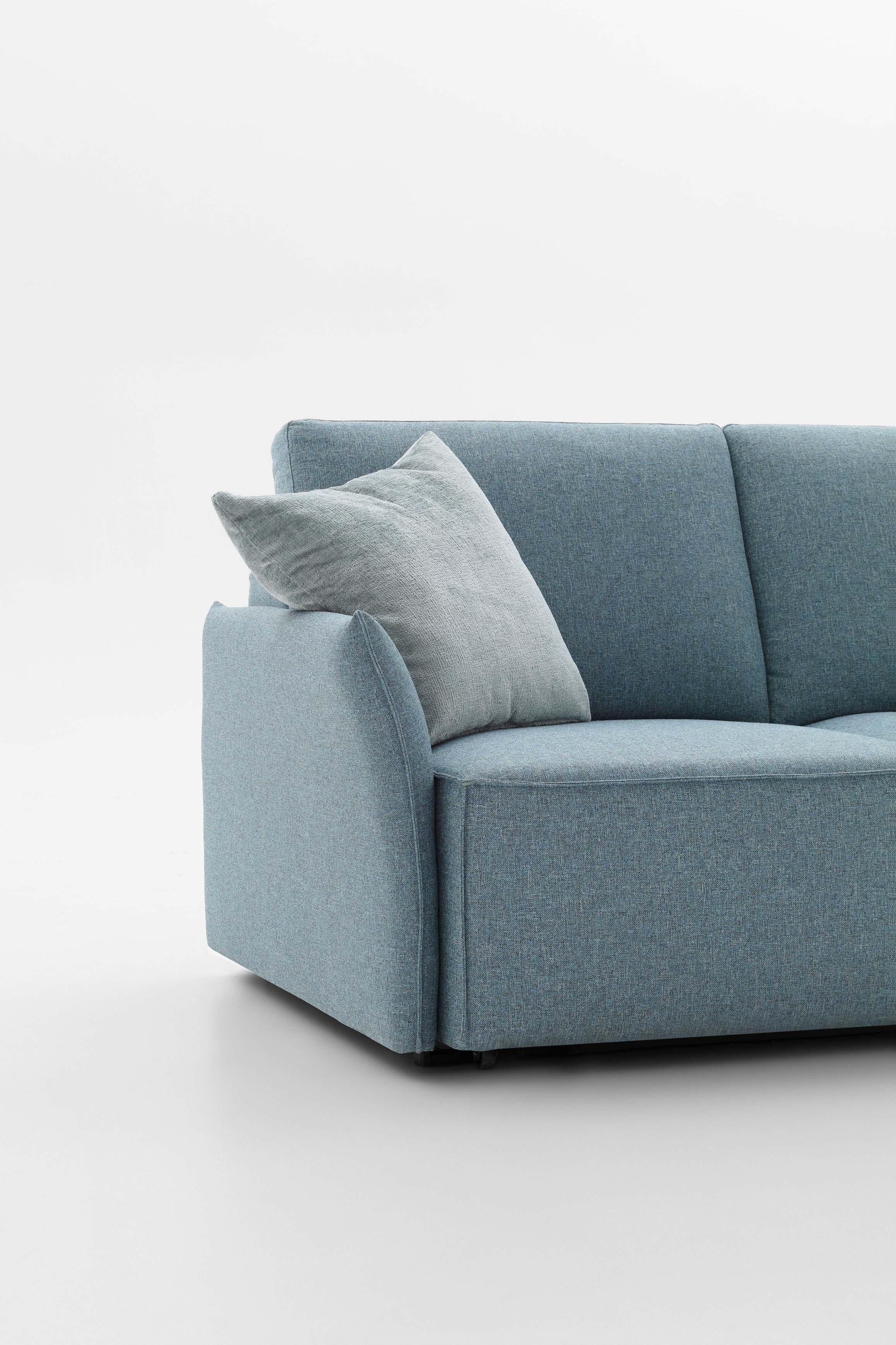 Detail of the super-thin Drai armrest of a light blue monocoque sofa