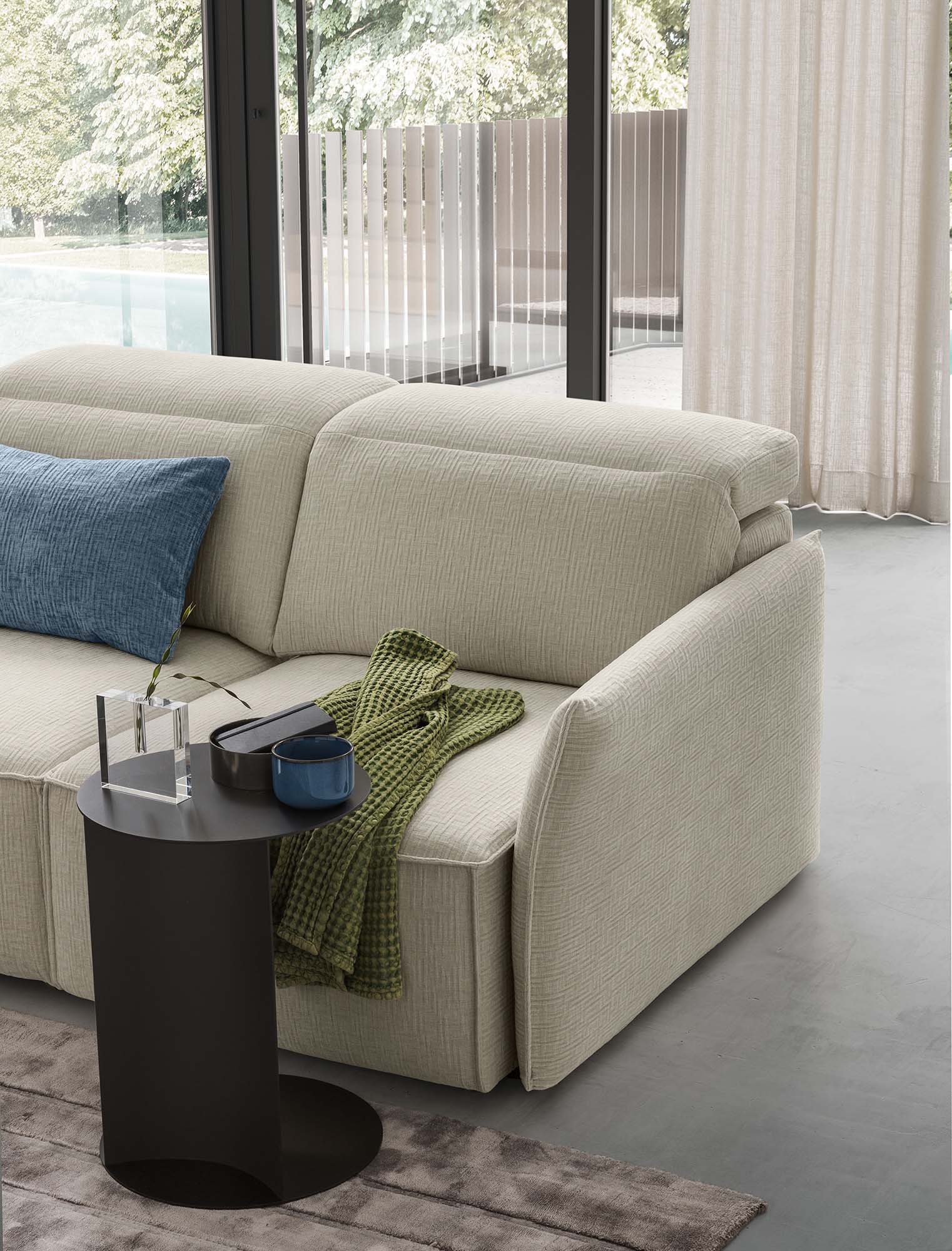 Seat of a sofa with adjustable headrests and a modern coffee table that fits into the sofa structure.
