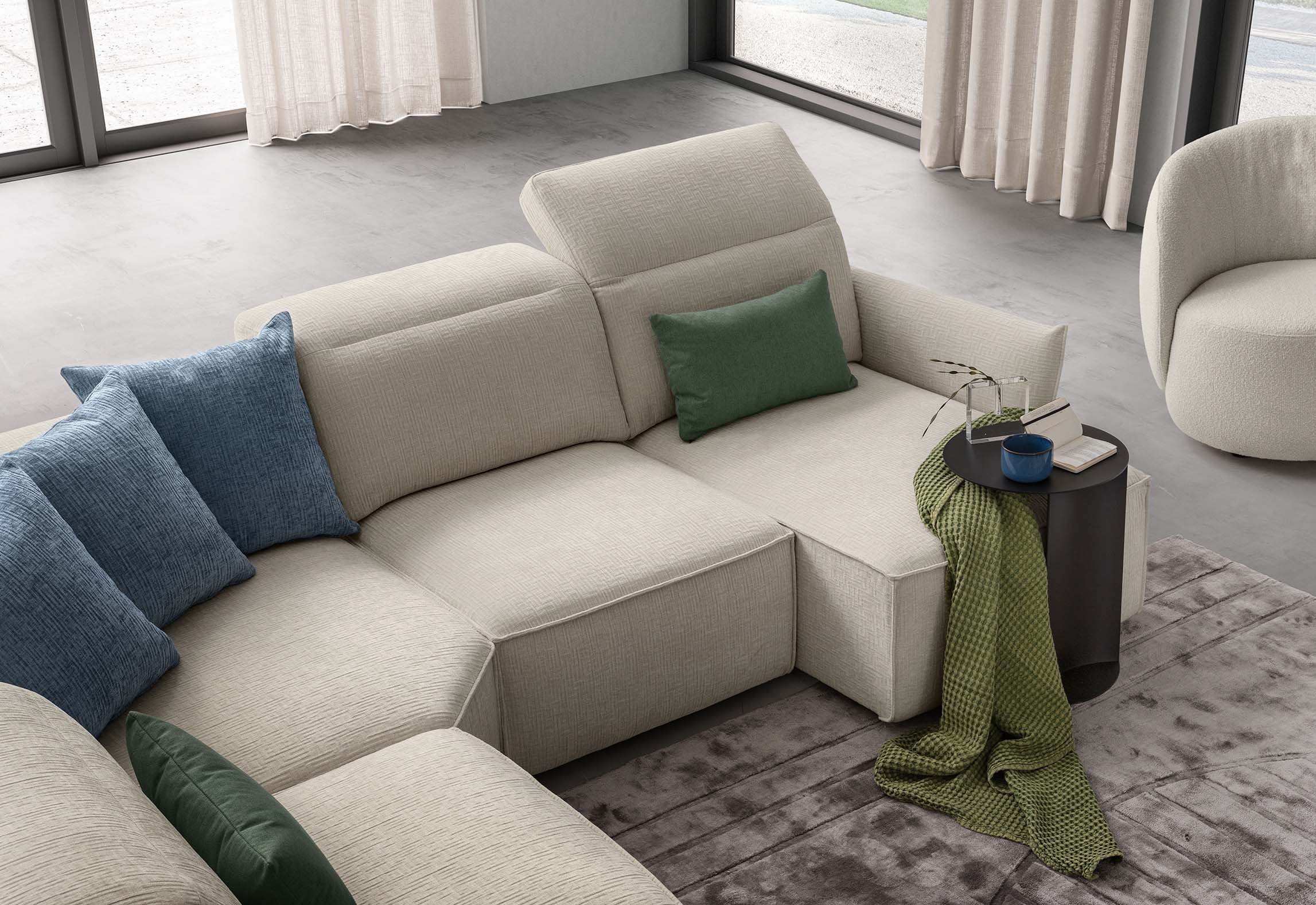 Modern corner sofa with adjustable headrests and comfortable and spacious pull-out seats. Cream white color.