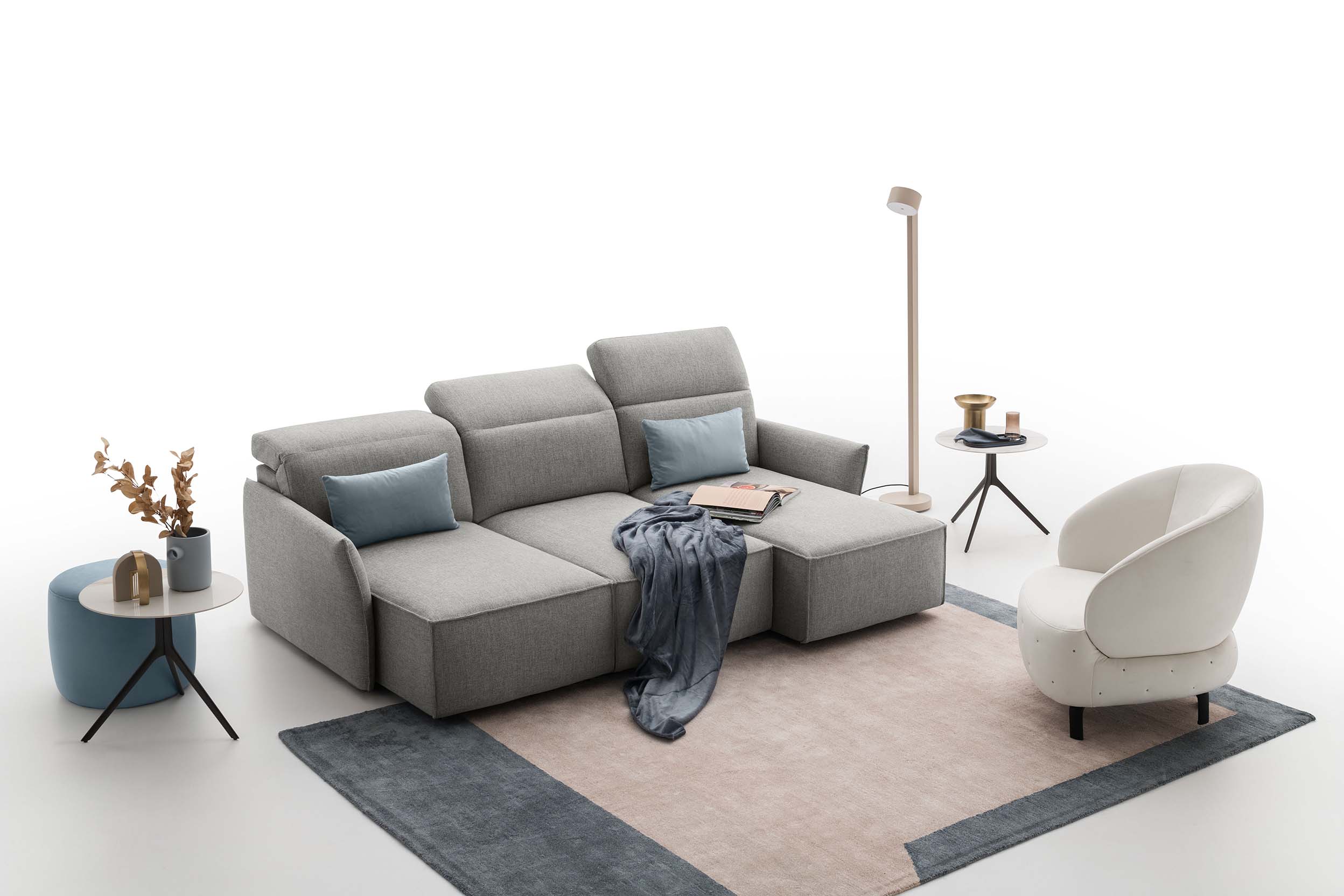 Small living room composed of a gray fabric sofa with open sliding seats, rug, armchair and accessories.