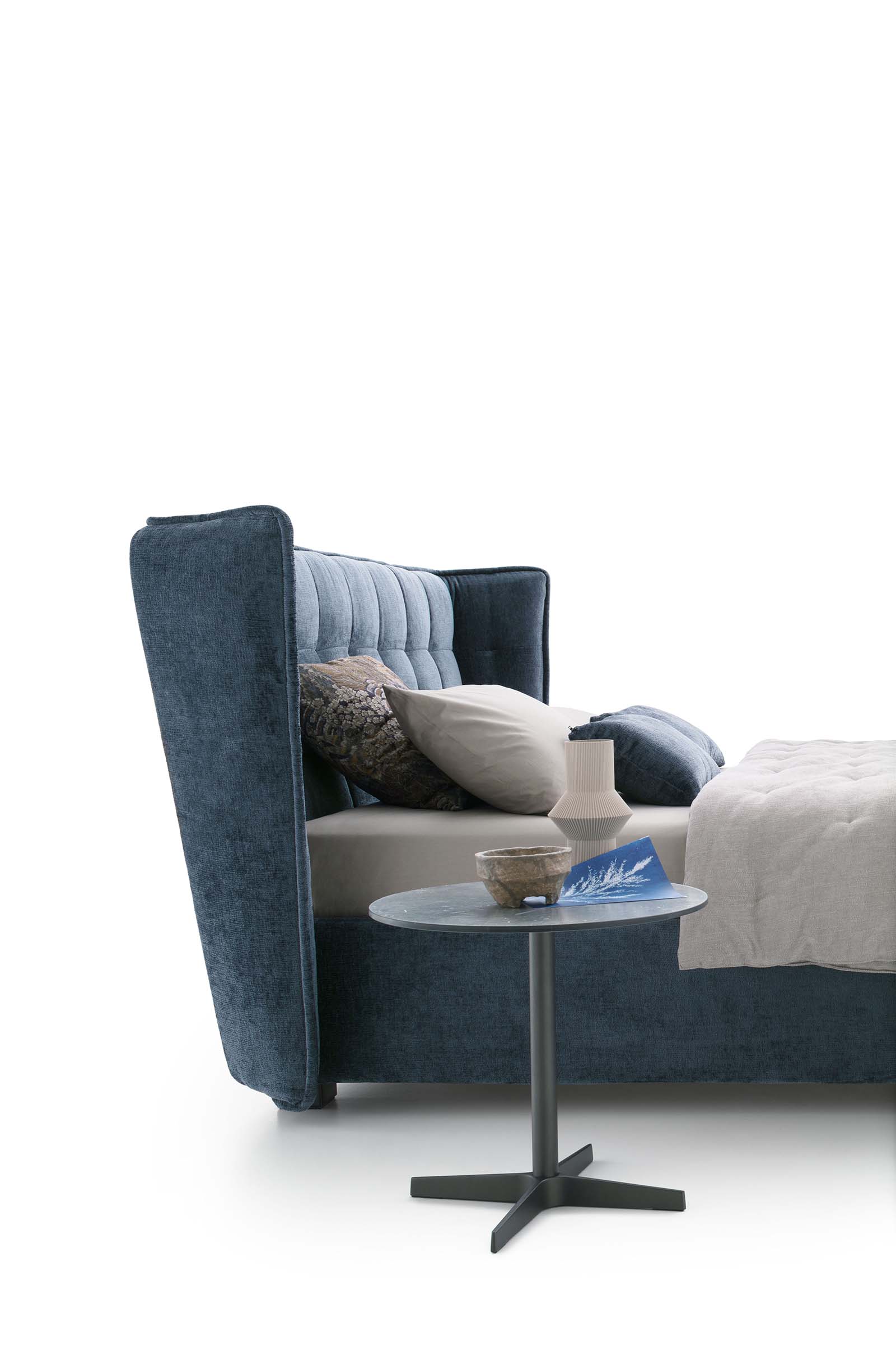 Detail of the quilted upholstered headboard of the blue Aspen bed