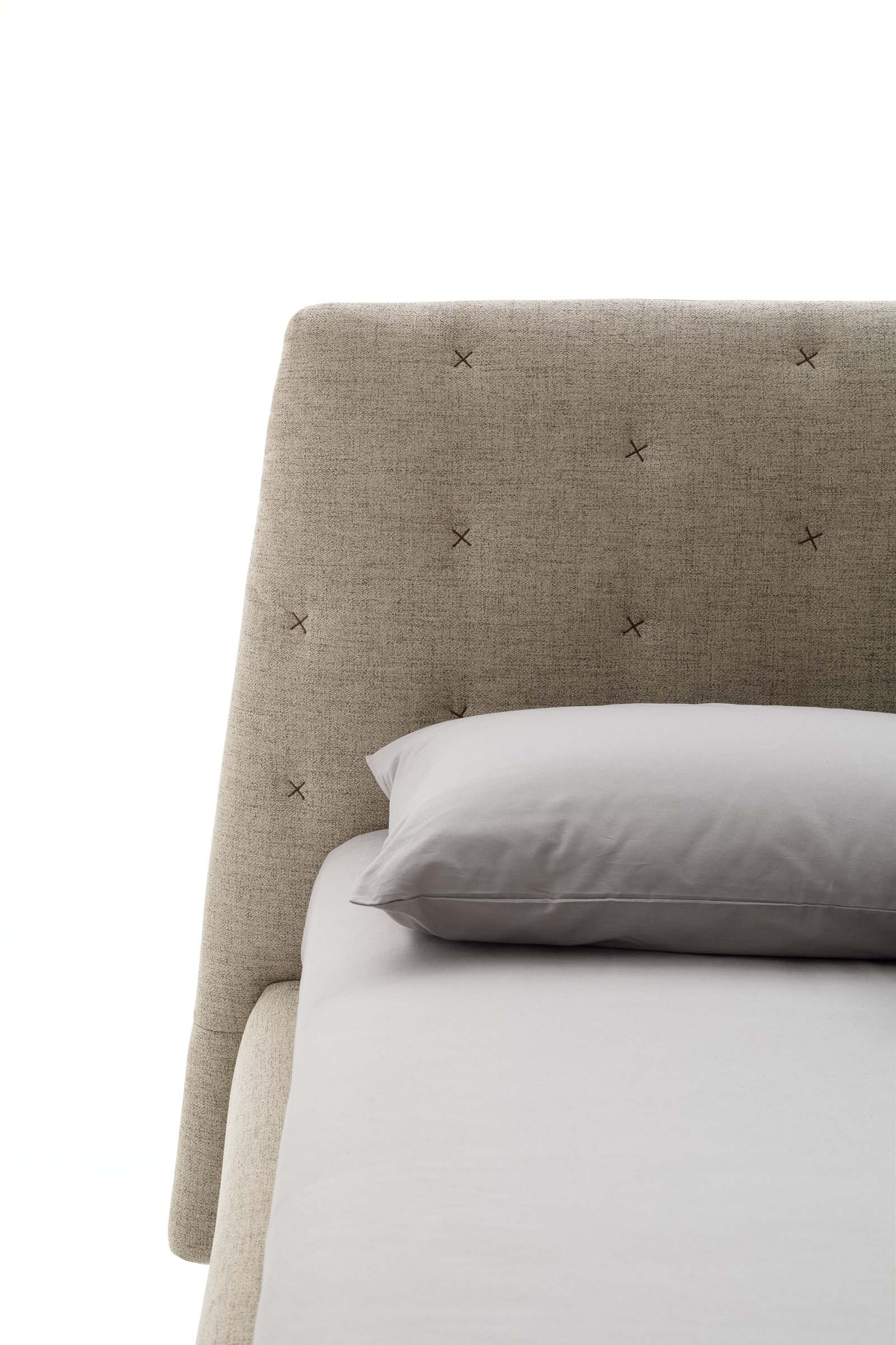 Tufted bed headboard with cross-stitching