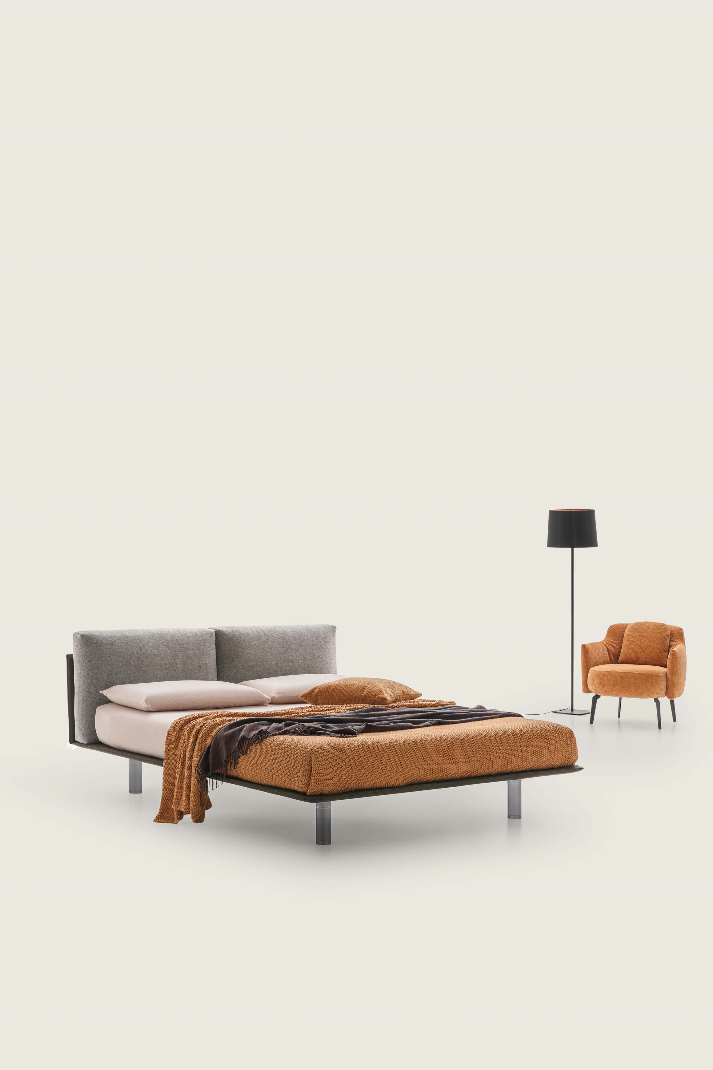 Bed with very thin dark gray bed frame and headboard with taupe upholstered cushions