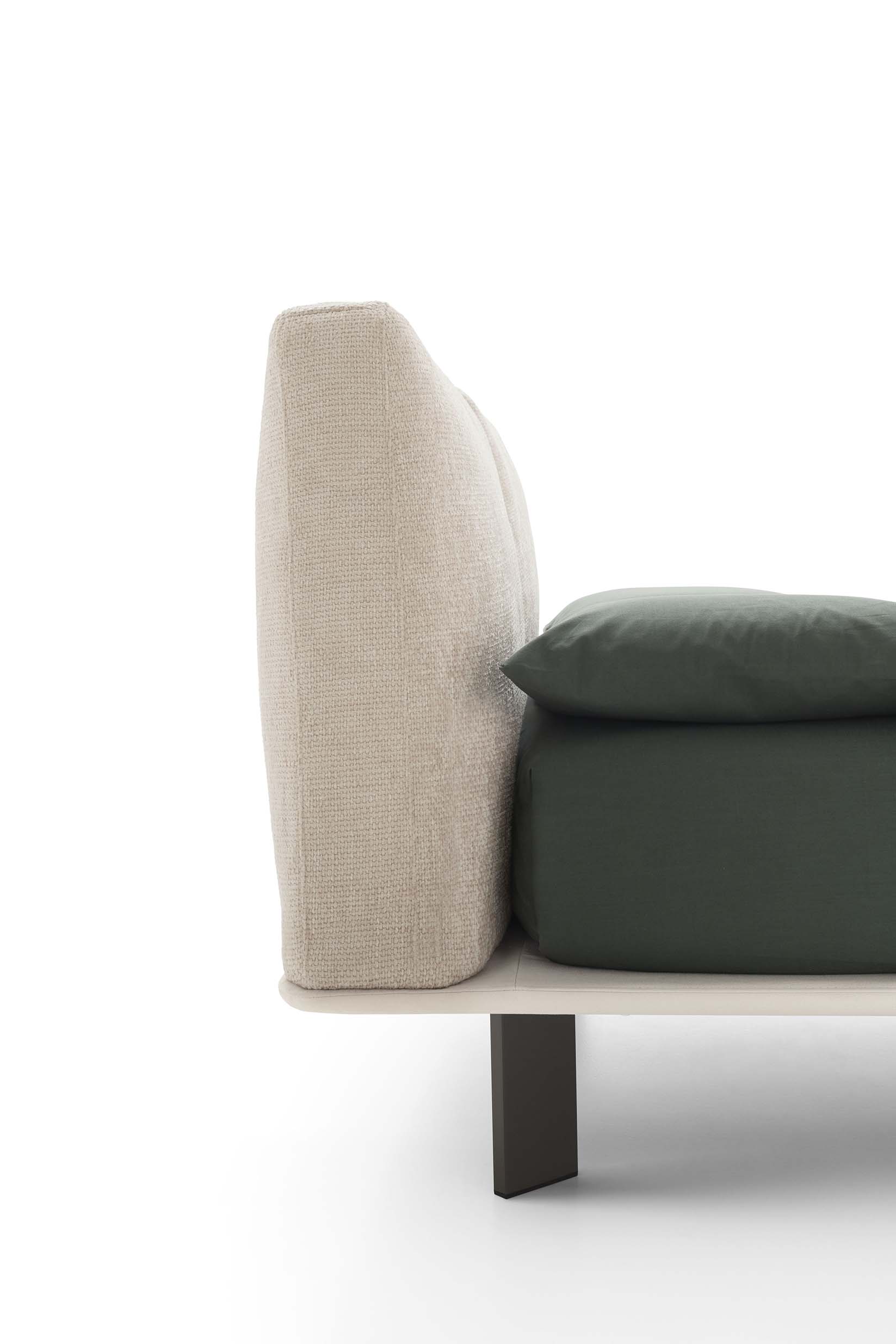 Detail of the soft and upholstered headboard of a bed with a very thin bed frame.