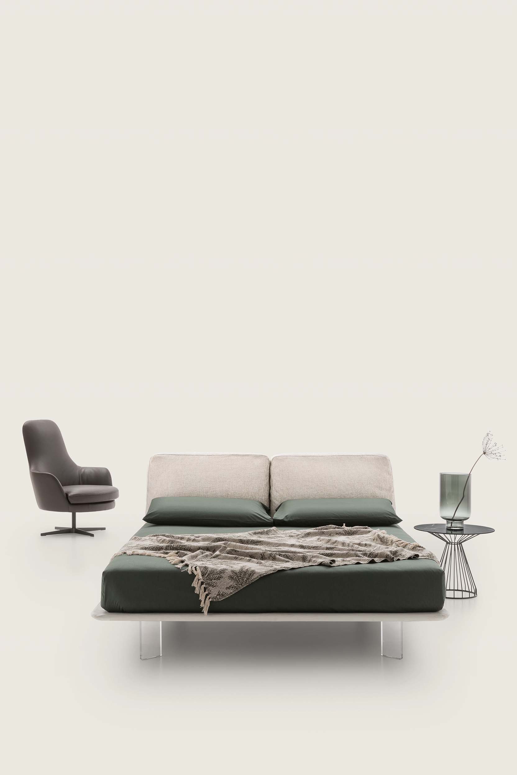 Ivory-colored double bed with high plexiglass feet and very thin bed frame