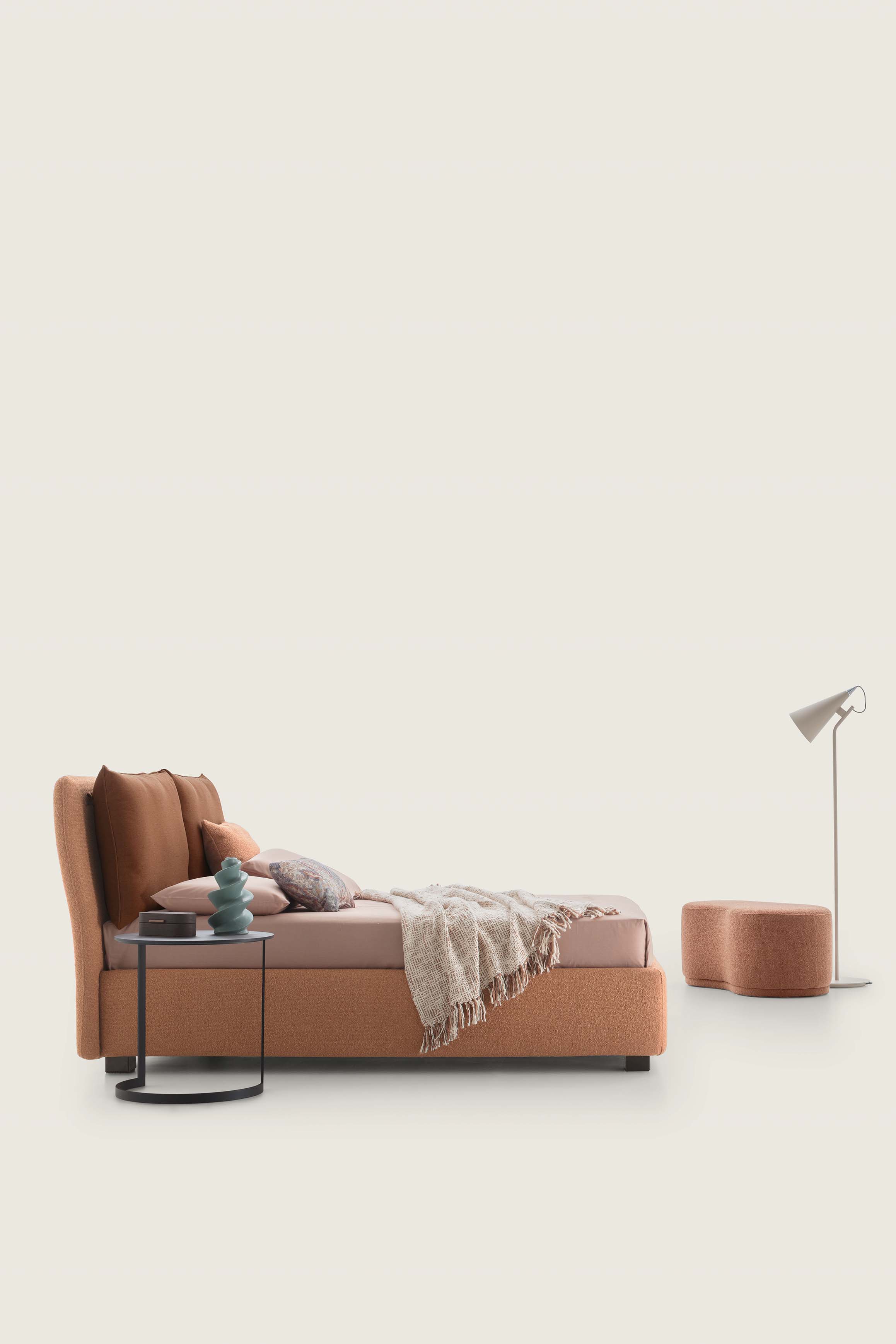 Low double bed in warm brick and orange tones
