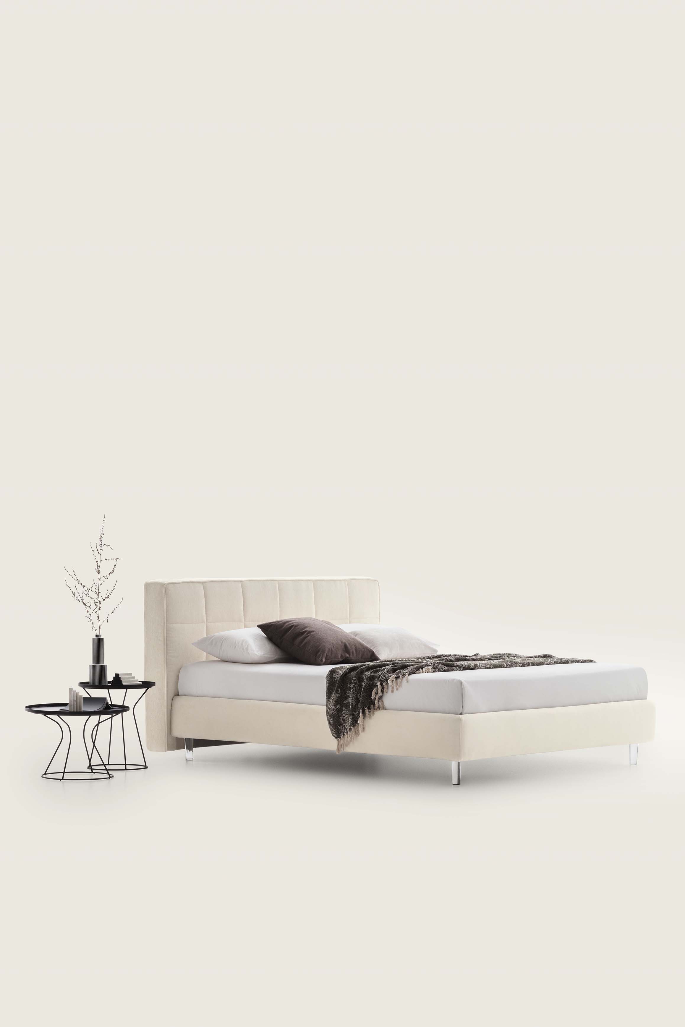 Creamy white double bed with square pattern and transparent feet
