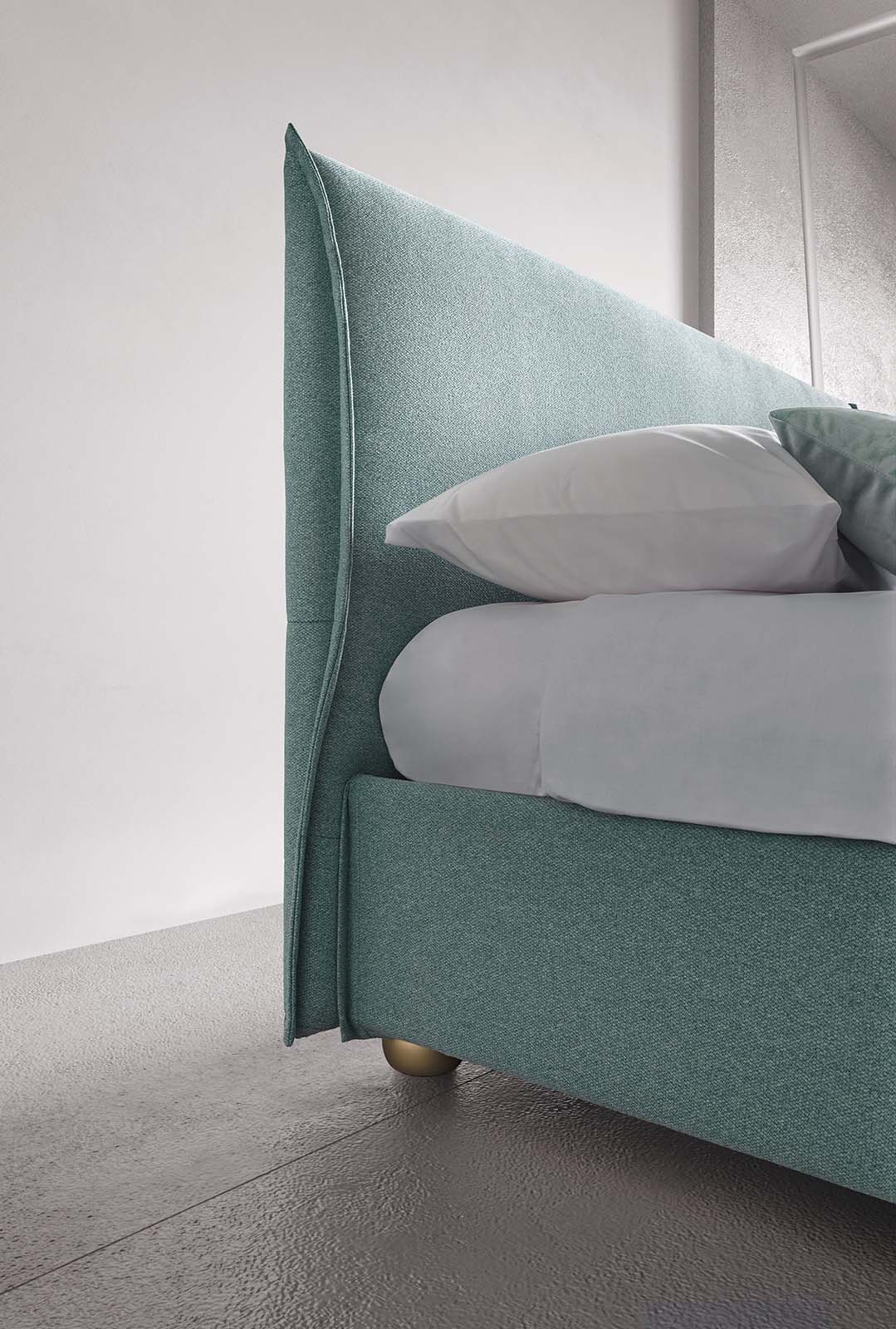 Detail of the thin and space-saving headboard of a space-saving double bed with white linens