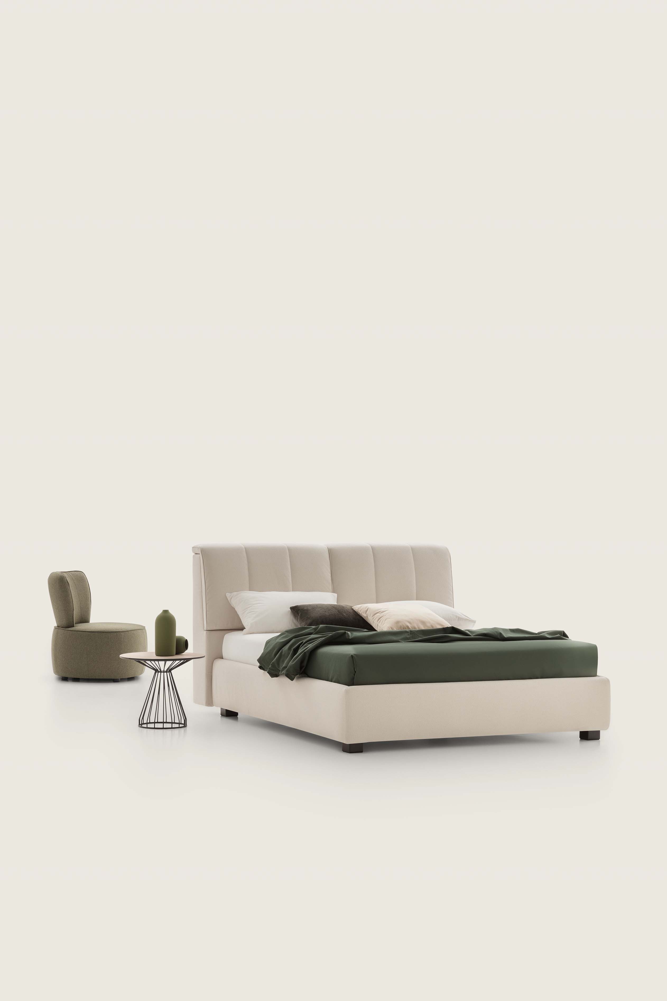 Modern low cream-colored bed with upholstered headboard and wide bed frame