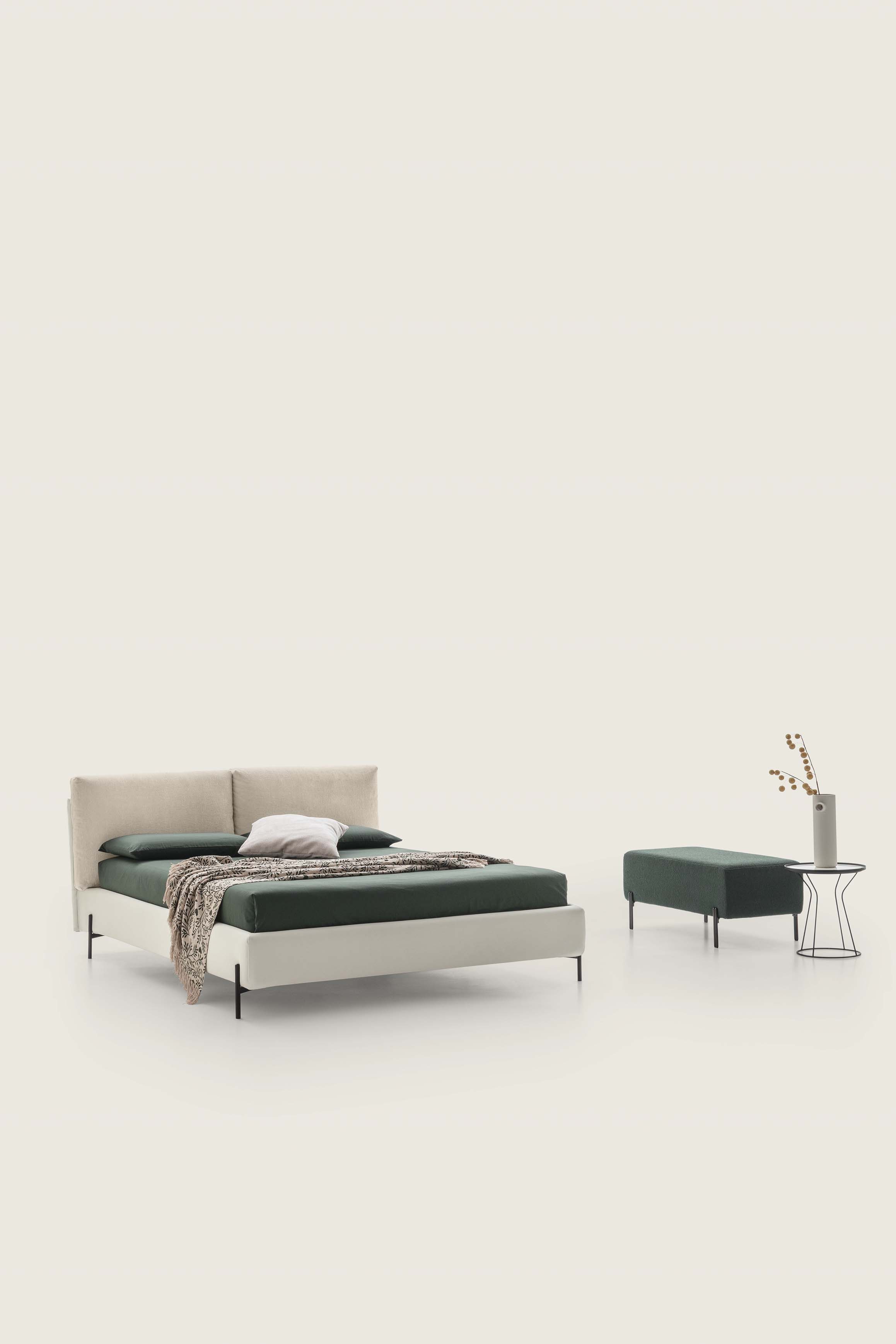 Modern two-tone cream-colored double bed with cushions and matching green bench