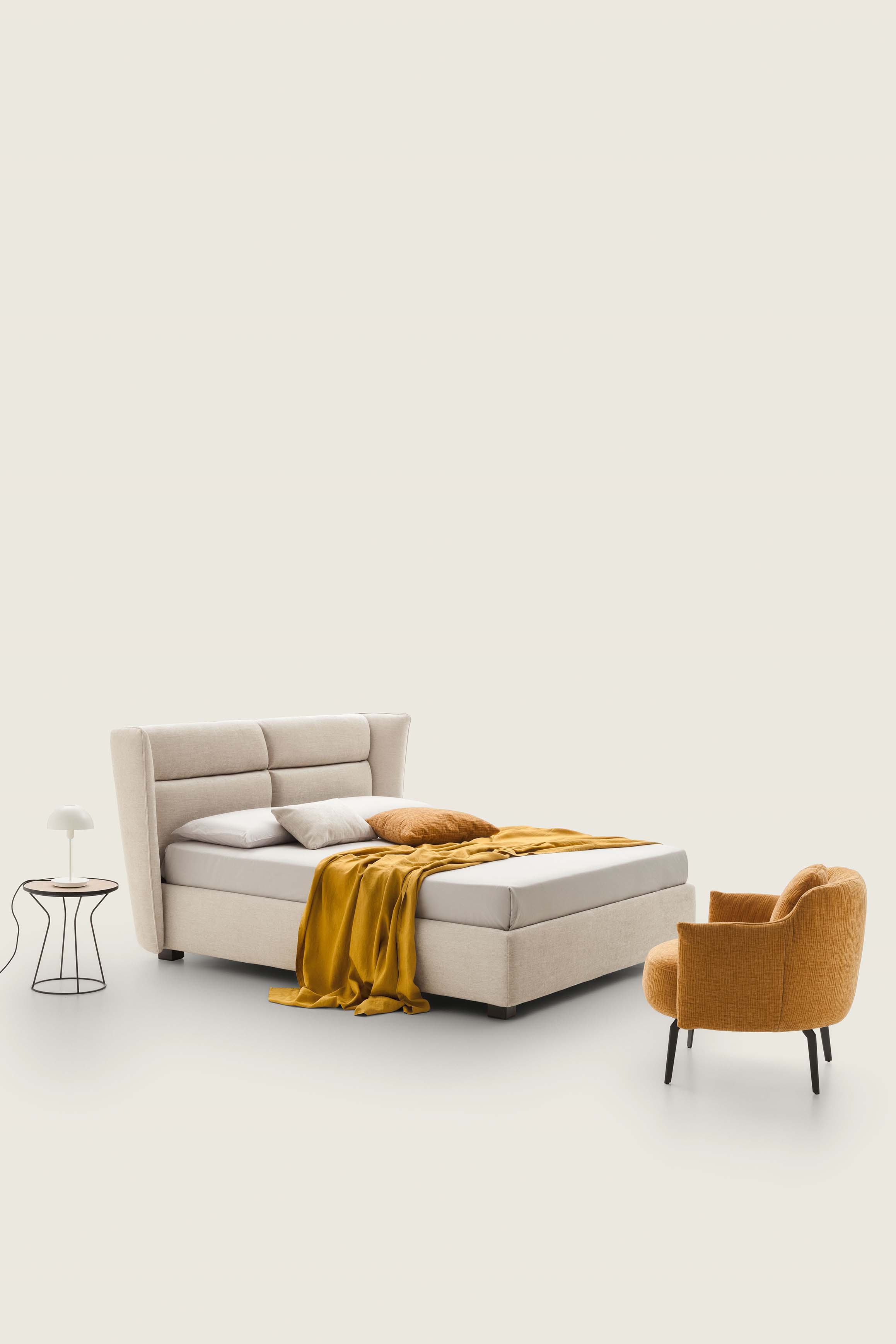 Cream-colored double bed with low feet and high headboard with quilting