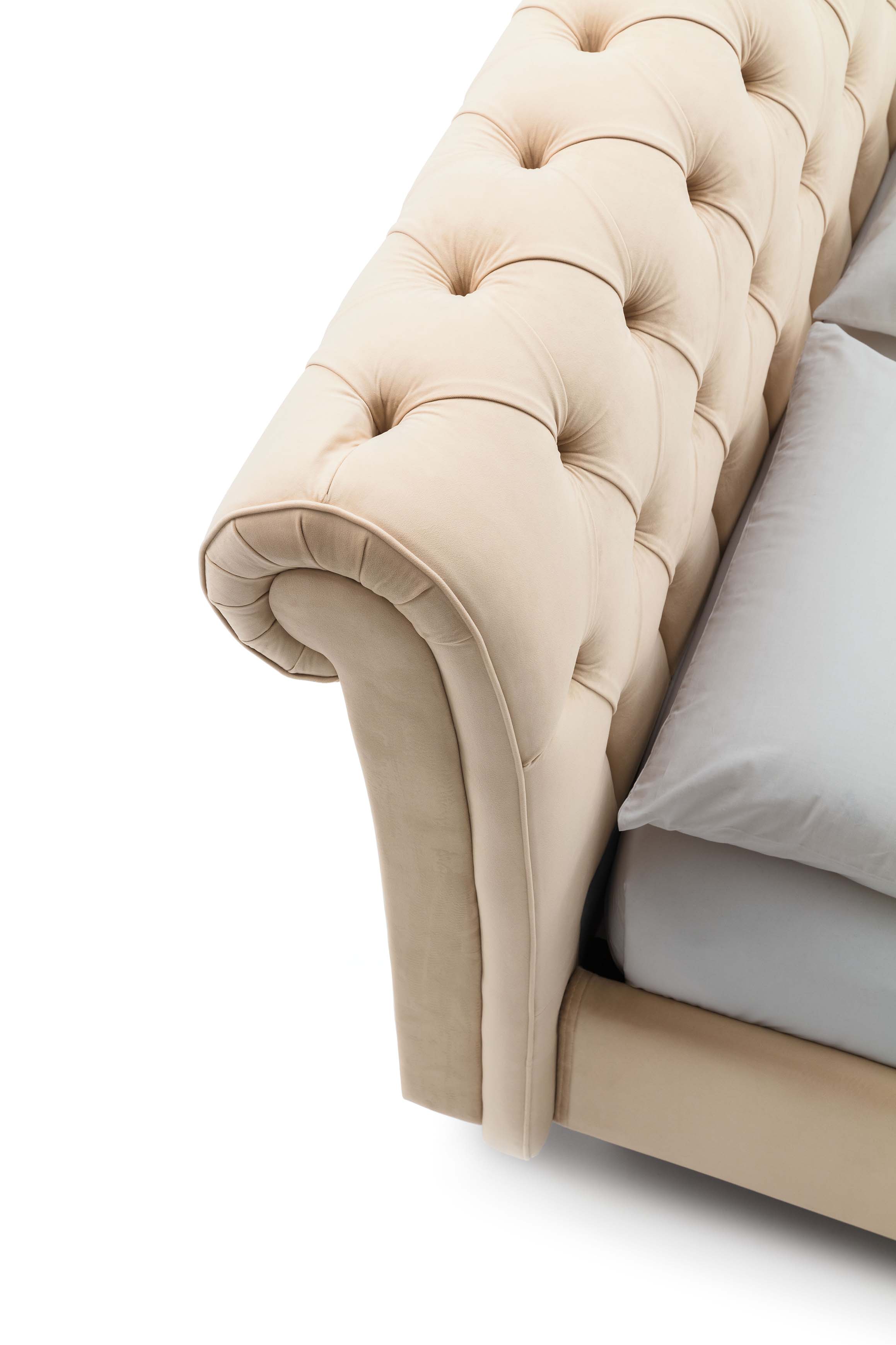 Cream-colored double bed with rolled-top tufted headboard