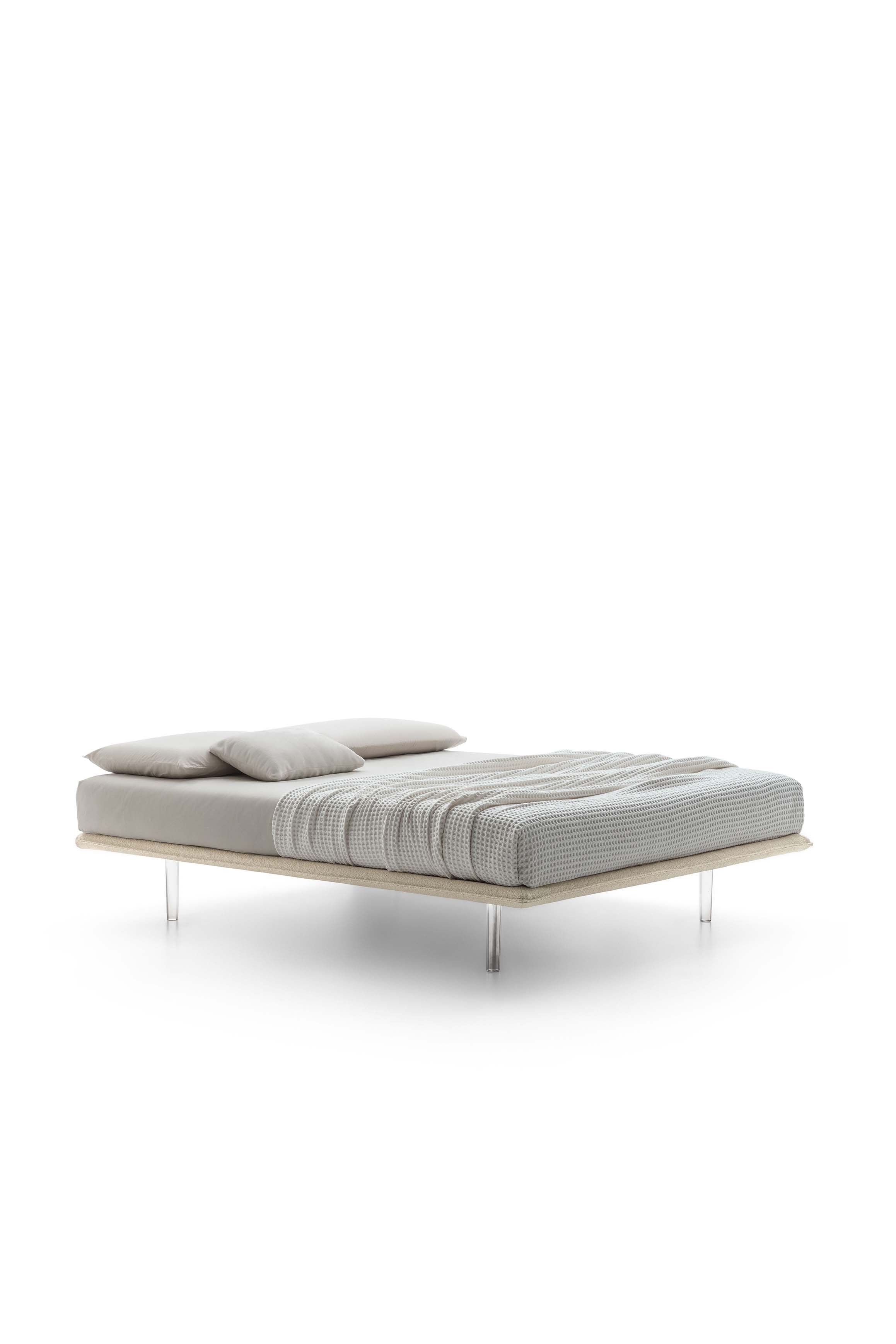Bed without headboard with high transparent plexiglass feet and thin bed frame