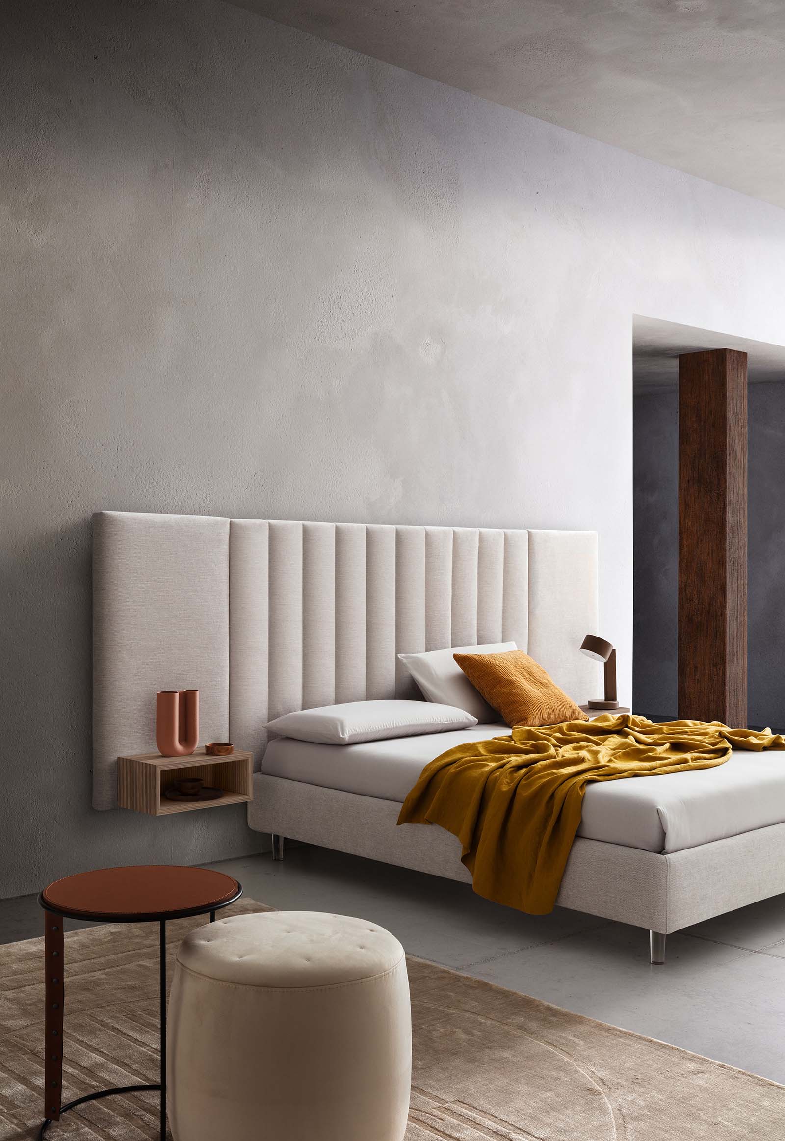 Room furnished with a white bed with plexiglass feet and wide upholstered headboard with vertical quilting