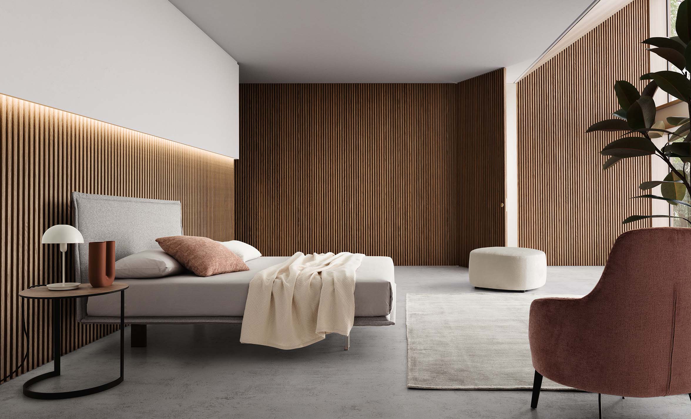 Modern room furnished with a space-saving bed combined with a pouf and a small table