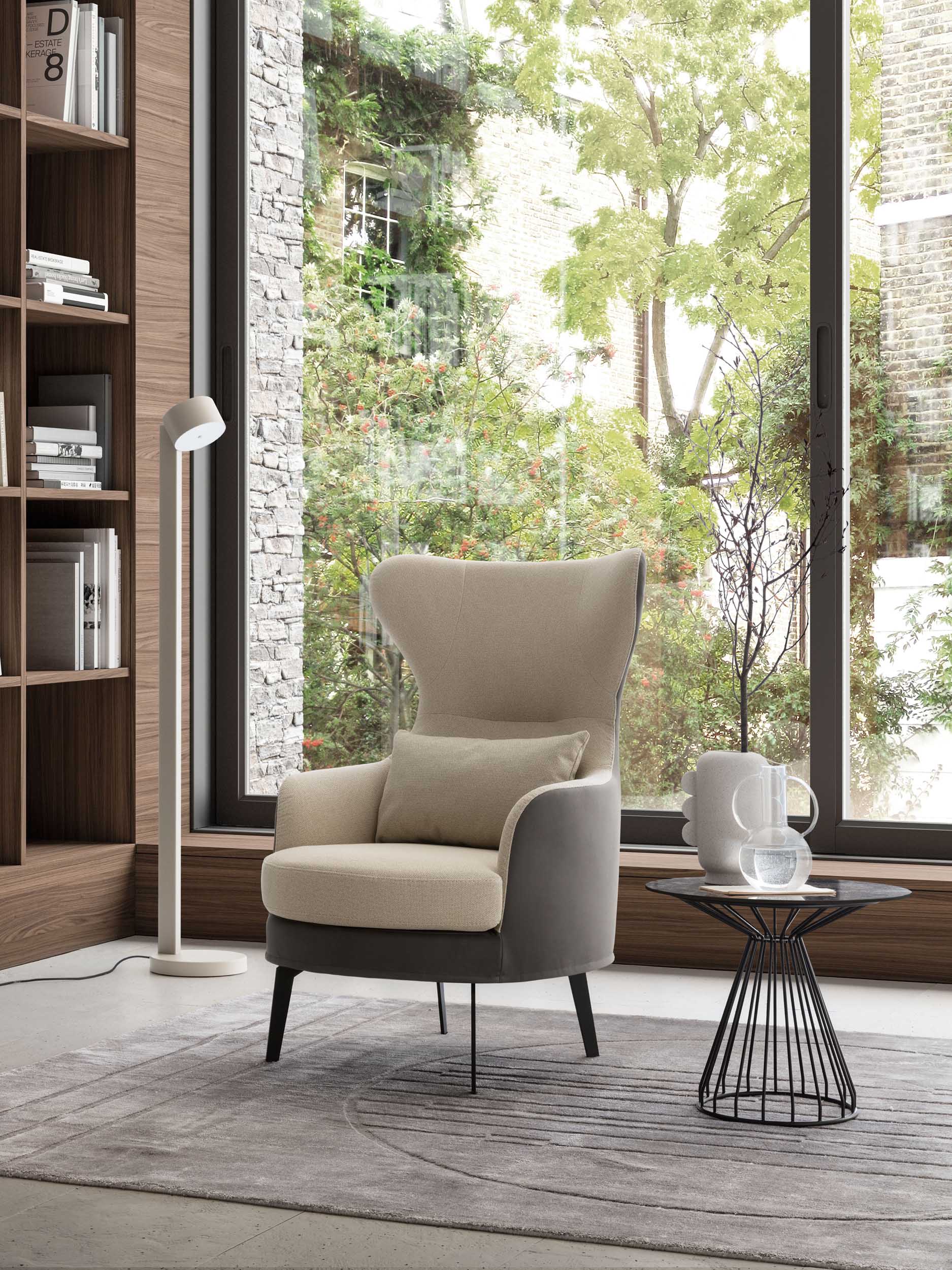 Modern armchair with a high backrest and lumbar cushion in a contemporary living room. Bicolor white and black