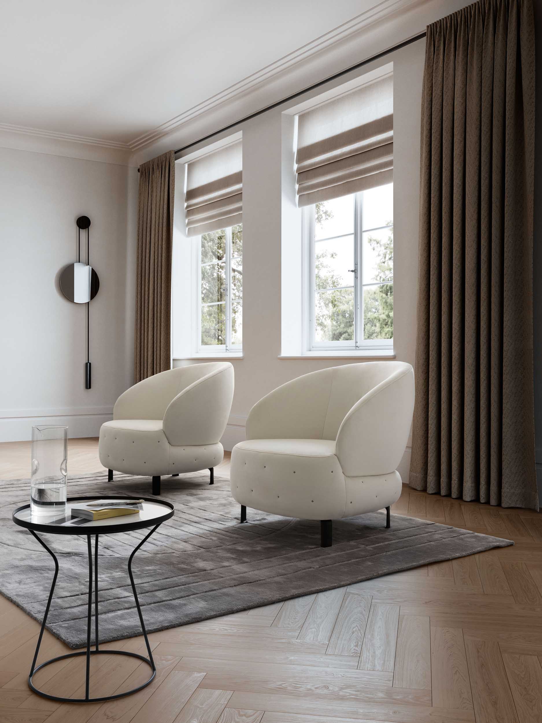 Pair of white quilted armchairs with a round seat in a contemporary living room