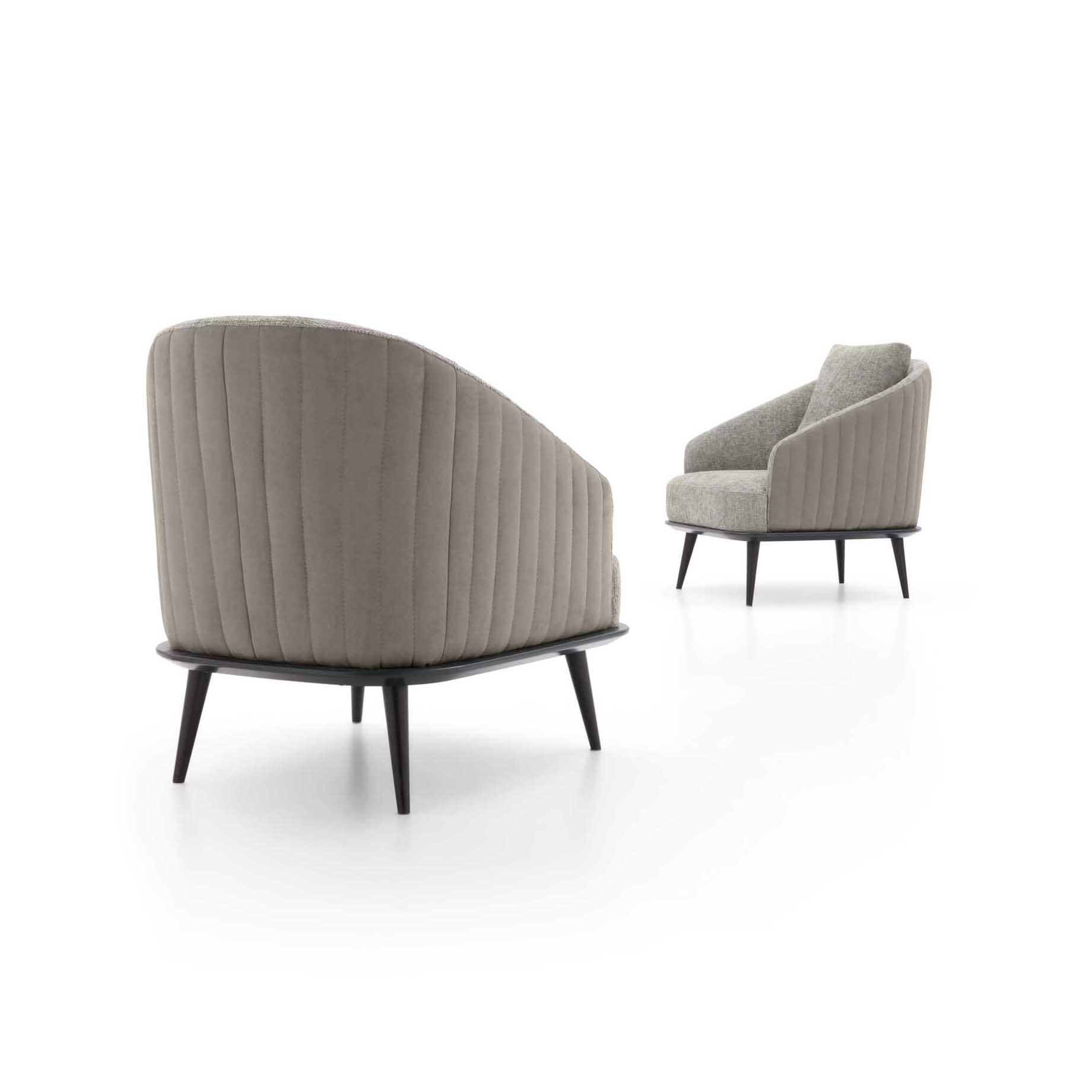 Comfortable armchair viewed from the back with vertical quilting details.