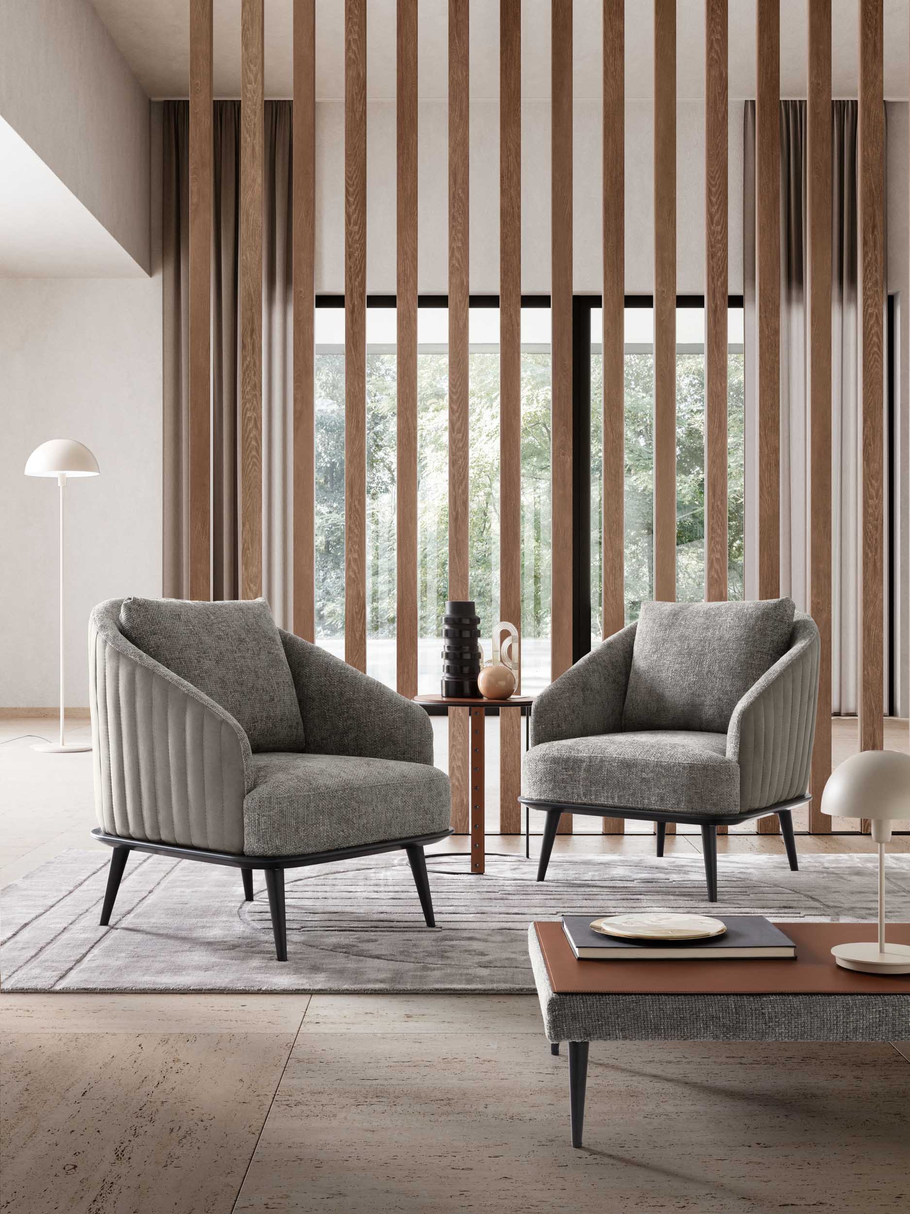 Living room furnished with comfortable gray upholstered armchairs with black legs