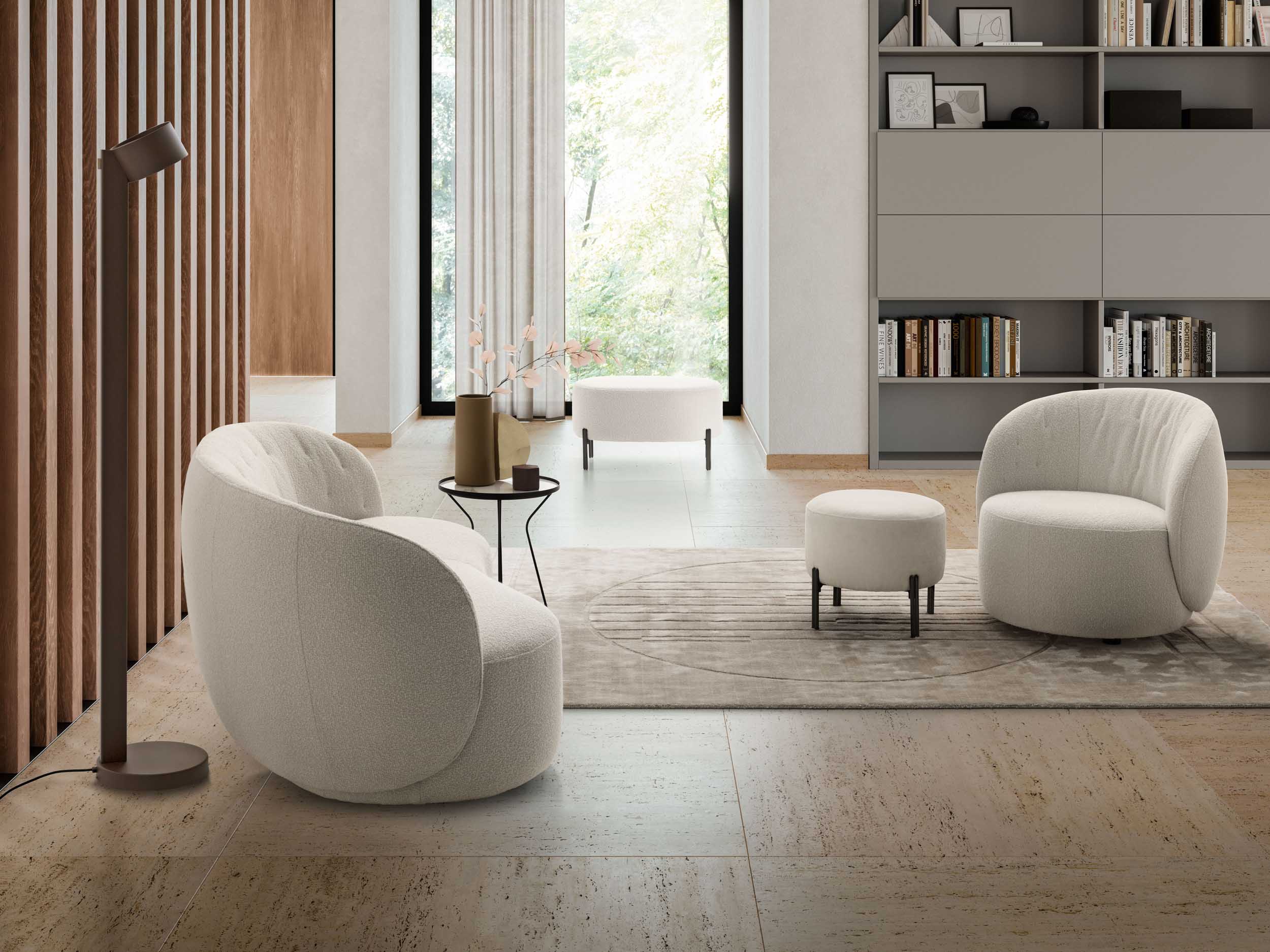 Modern lounge with a white fabric armchair, loveseat, and pouf
