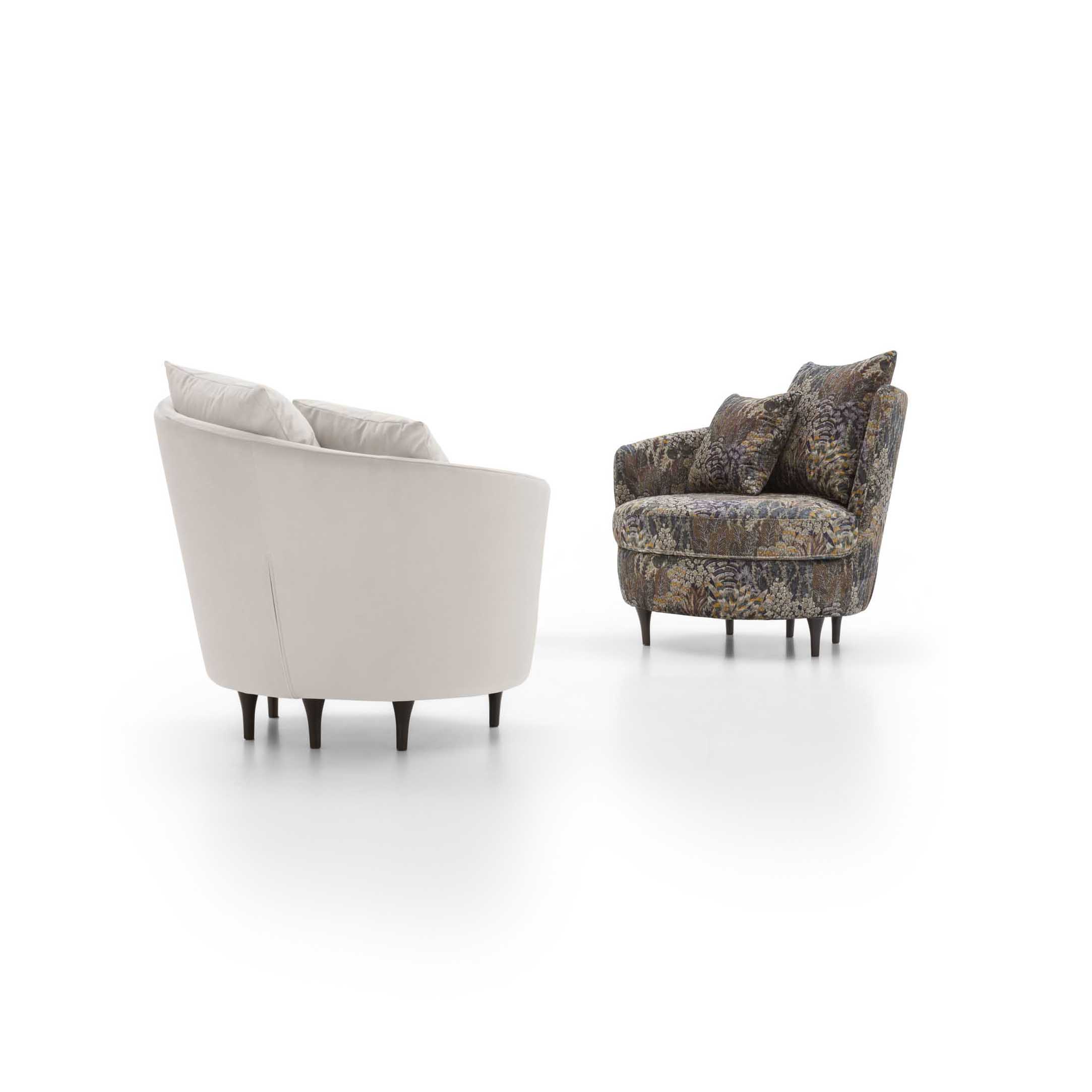 Asymmetrical upholstered armchair with two cushions: white version and floral pattern.